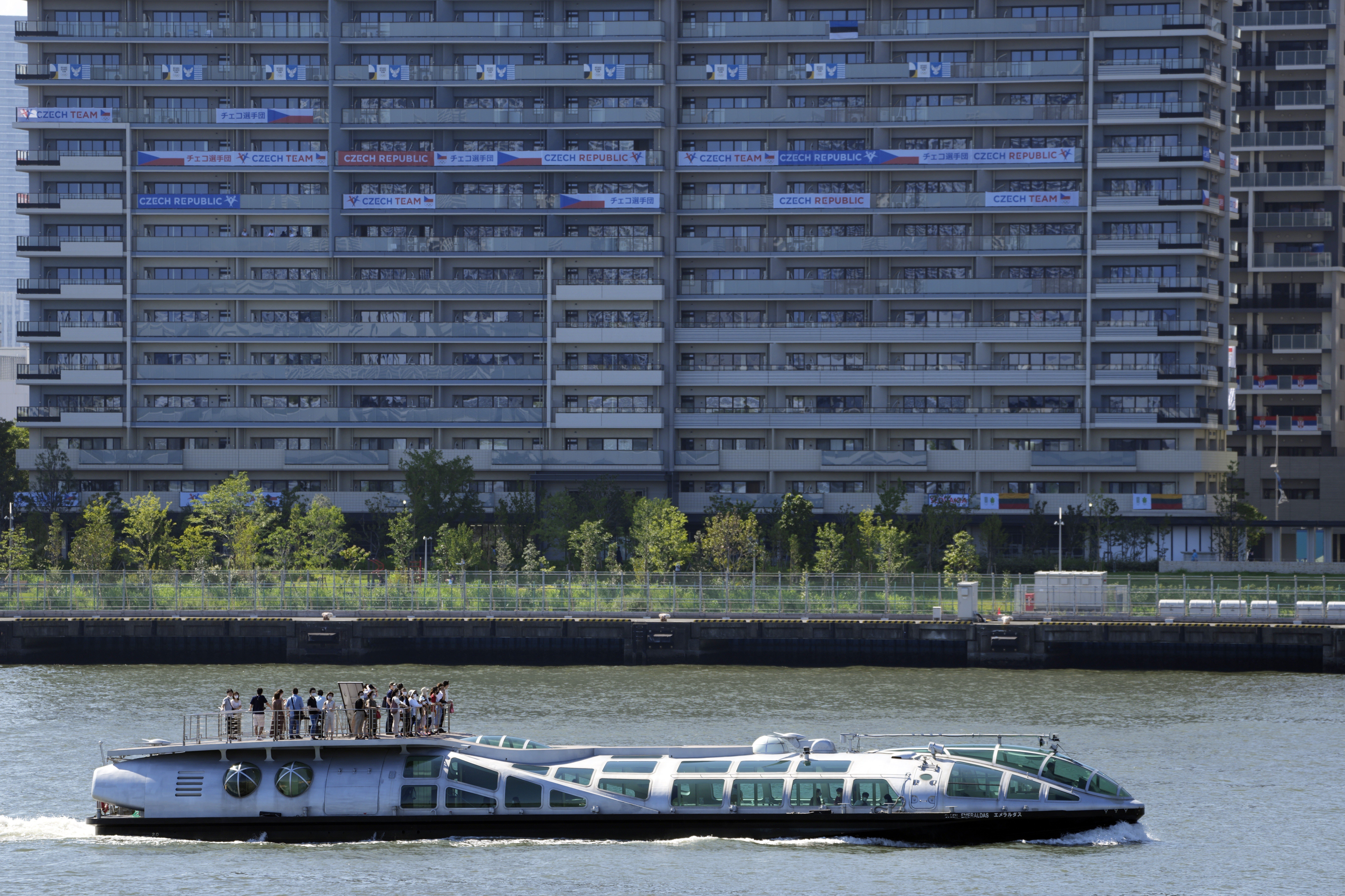 A tourist ship cruises past the Olympic Village buildings in Tokyo, where the first Covid-19 case was detected on Saturday. Photo: EPA