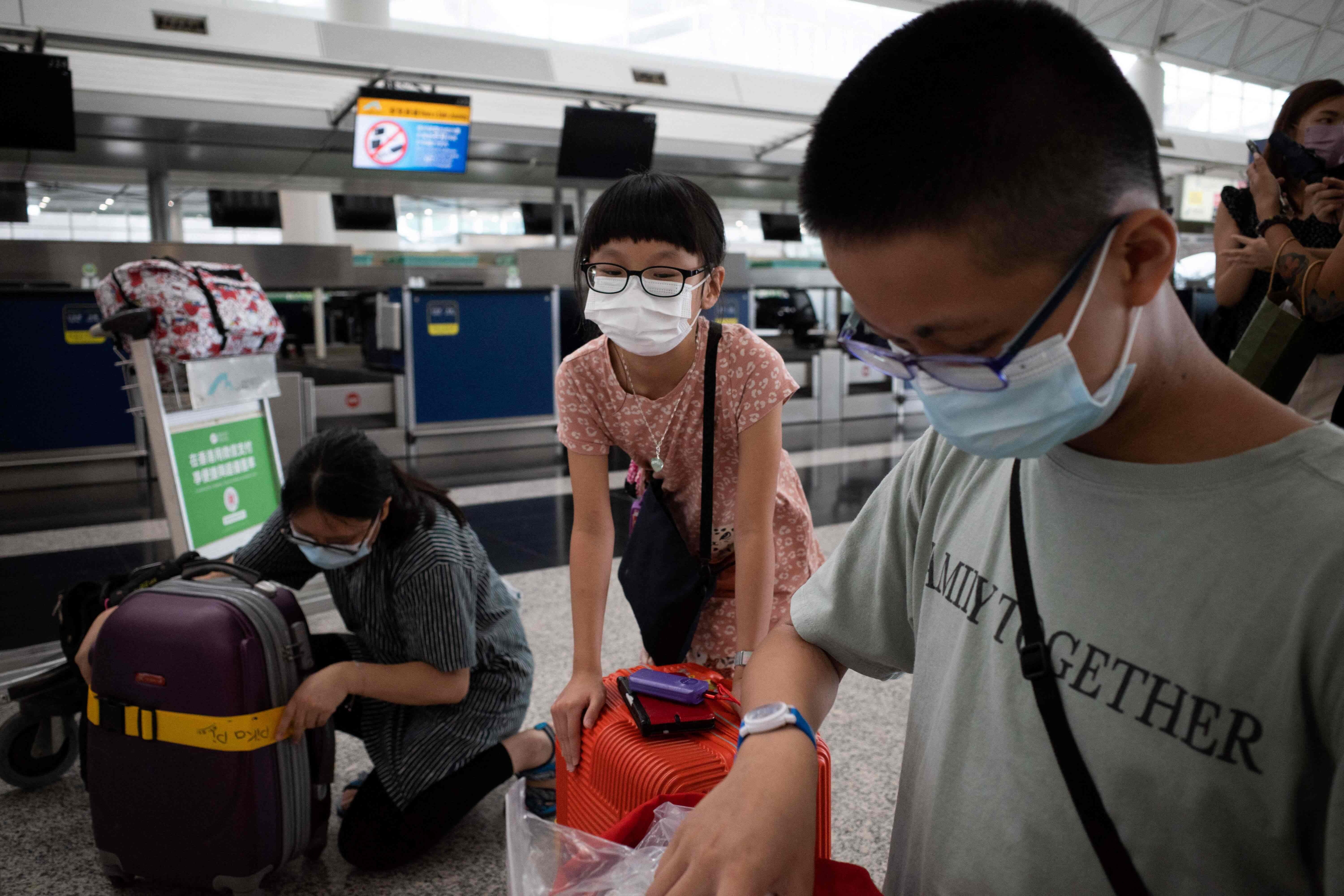 A family check their luggage before boarding a flight from Hong Kong to the UK. Photo: AFP