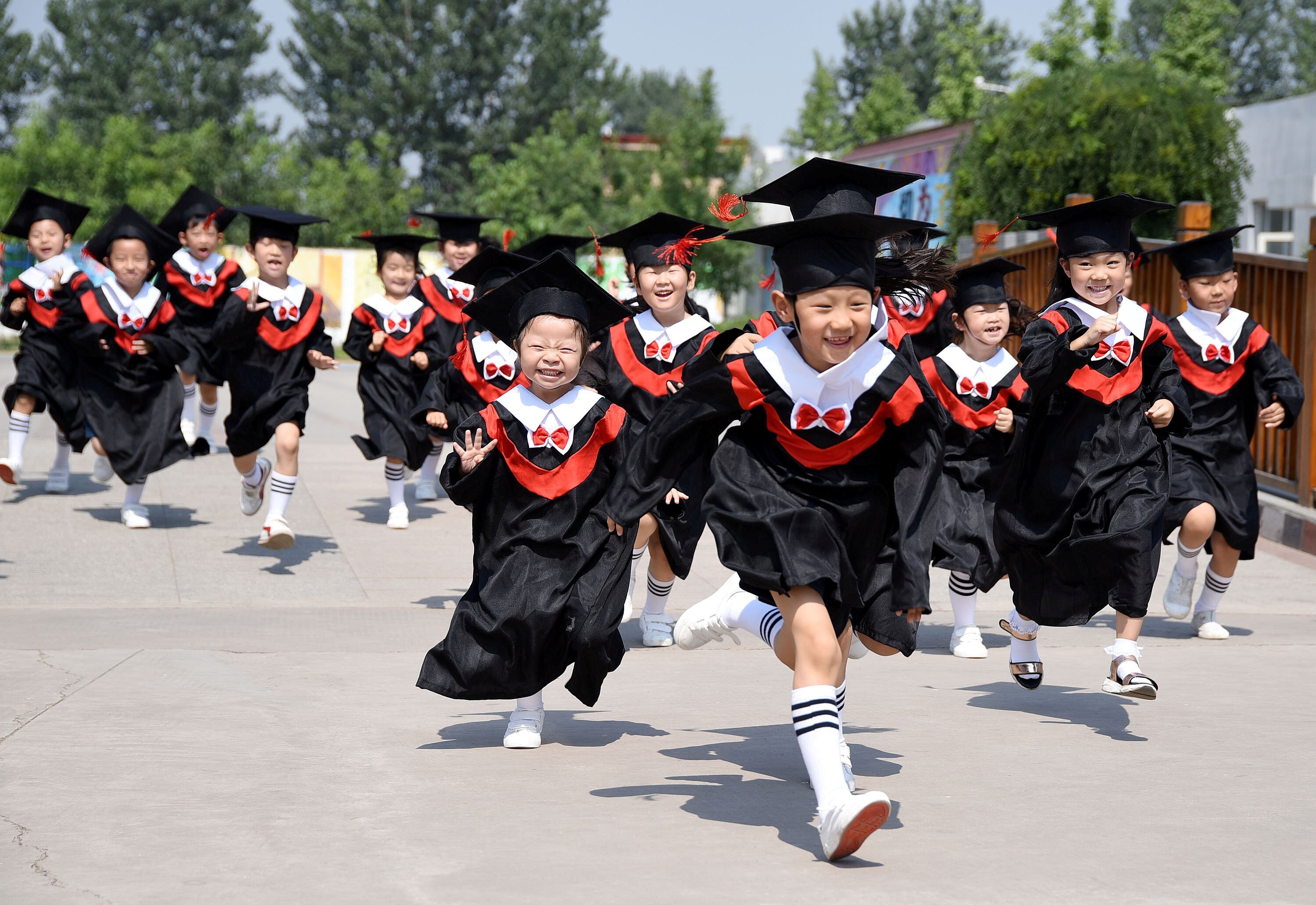Children in gowns and mortar boards during their kindergarten graduation ceremony in Handan, Hebei province on June 20, 2017. Photo: China Daily via Reuters