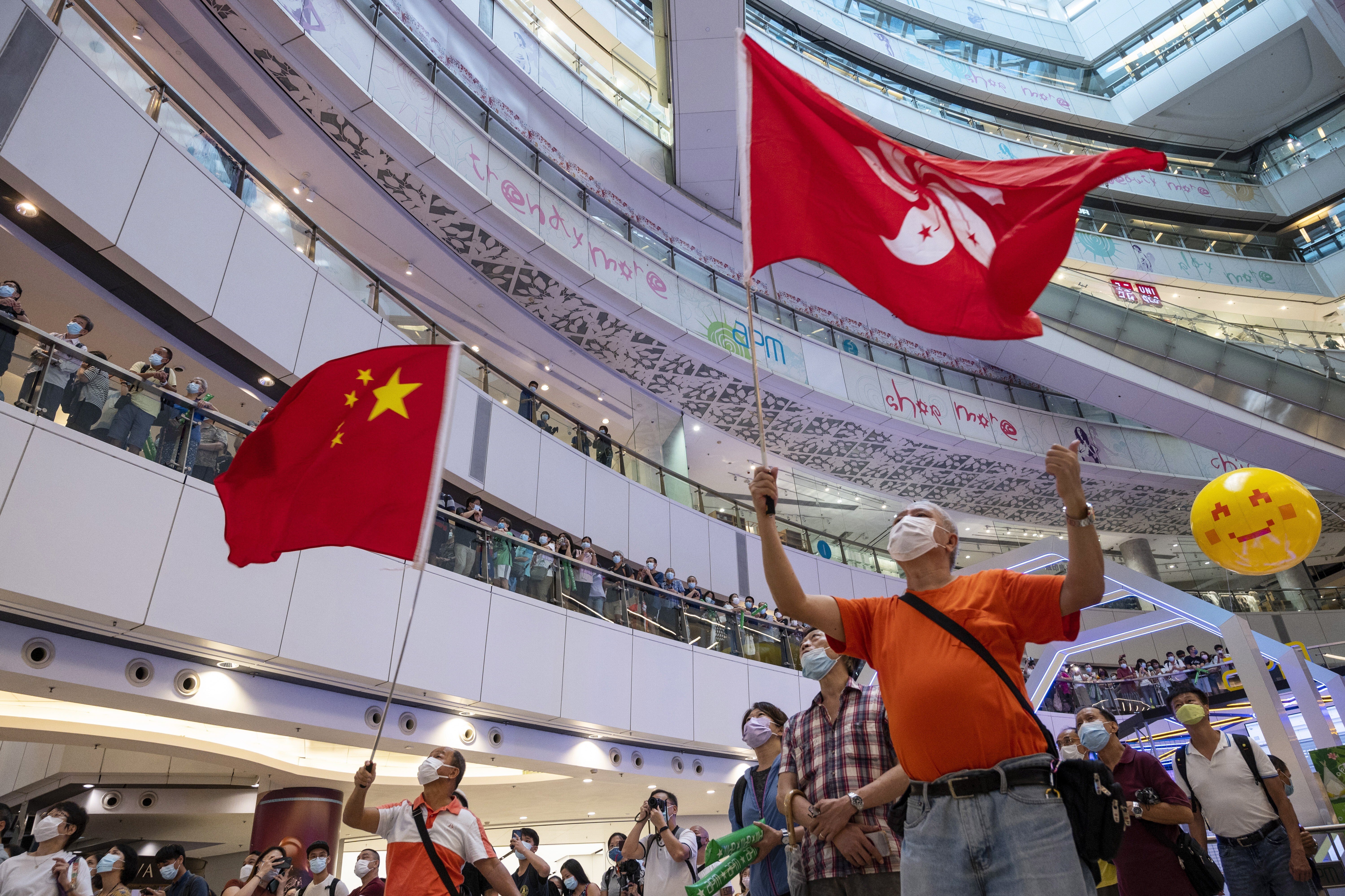 People watch a broadcast of Hong Kong swimmer Siobhan Haughey's silver medal win in the women's 100m freestyle final, in a mall, on July 30, 2021. Photo: EPA-EFE