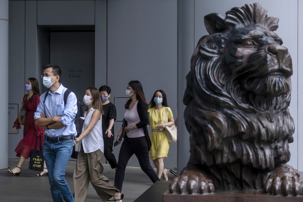 Commuters walk outside HSBC’s main building in Central. HSBC kicks off earnings season for Hong Kong’s biggest banks when it reports its first-half results on Monday. Photo: Bloomberg
