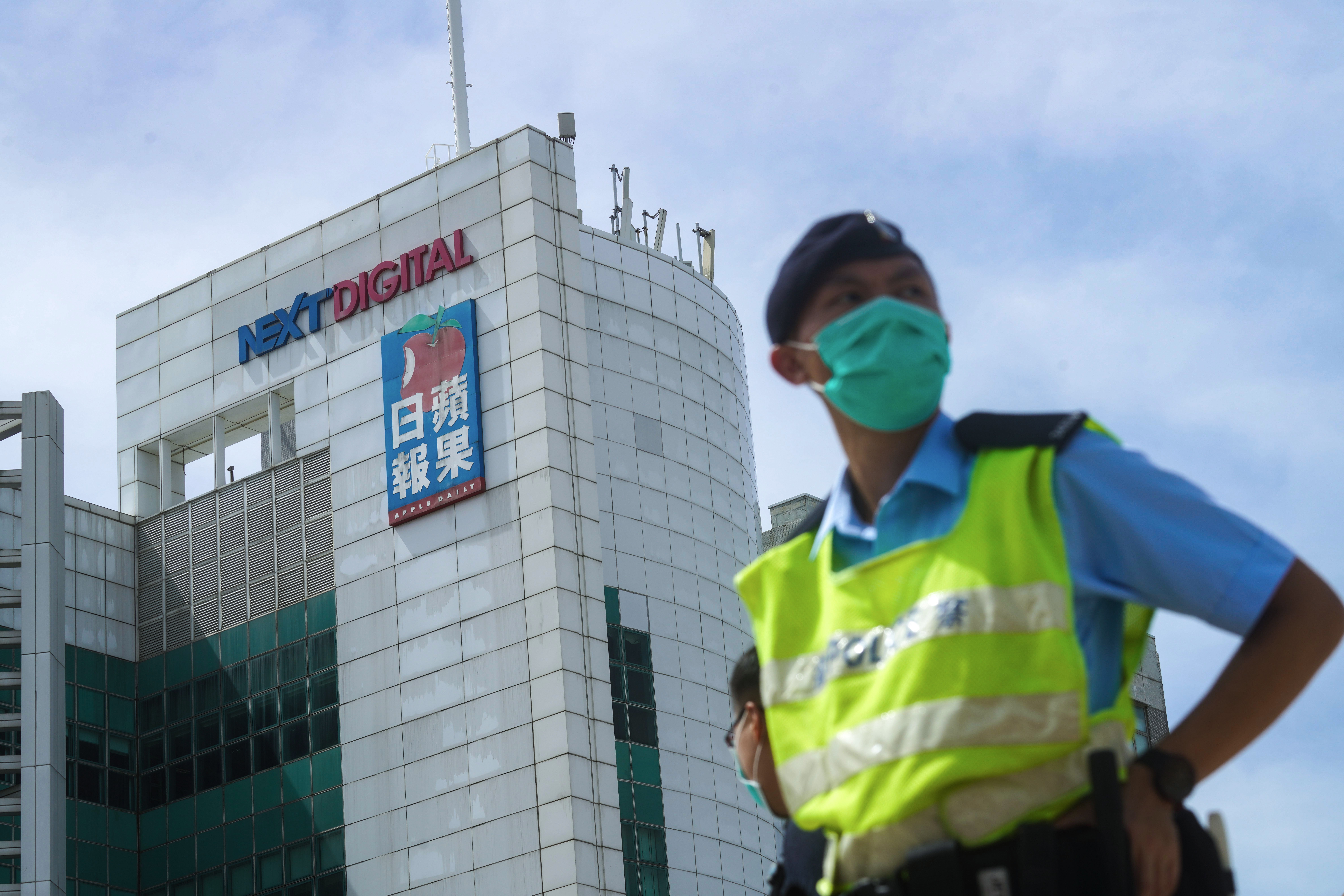 Police officers watch over a search operation outside Next Digital’s head office in Tseung Kwan O, Hong Kong. Photo: Winson Wong