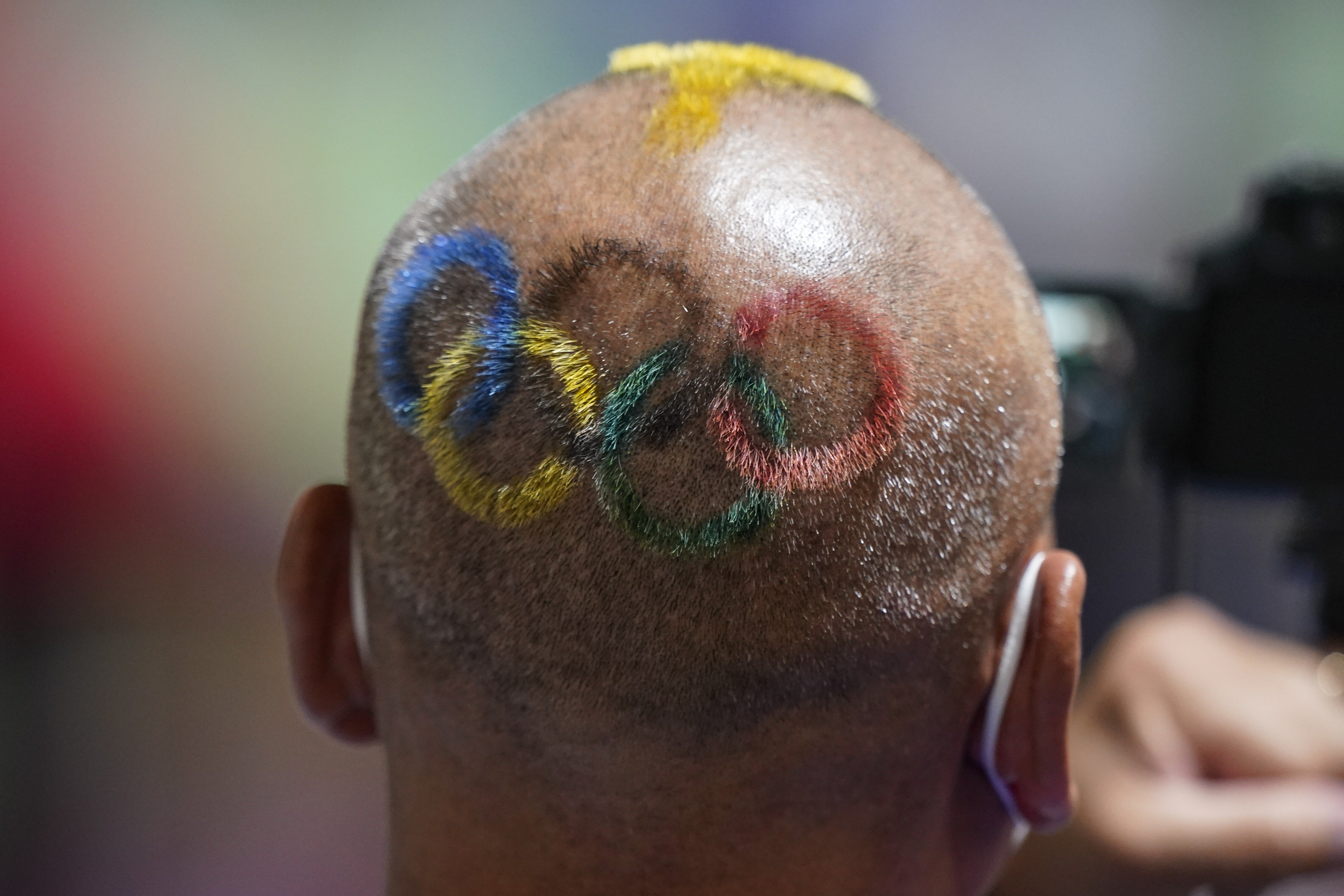 Mongolian coach Undralbat Lkhagva has the Olympic rings cut and dyed into his hair as he watches the women’s 10m air pistol at the Asaka Shooting Range in Tokyo. Photo: AP Photo
