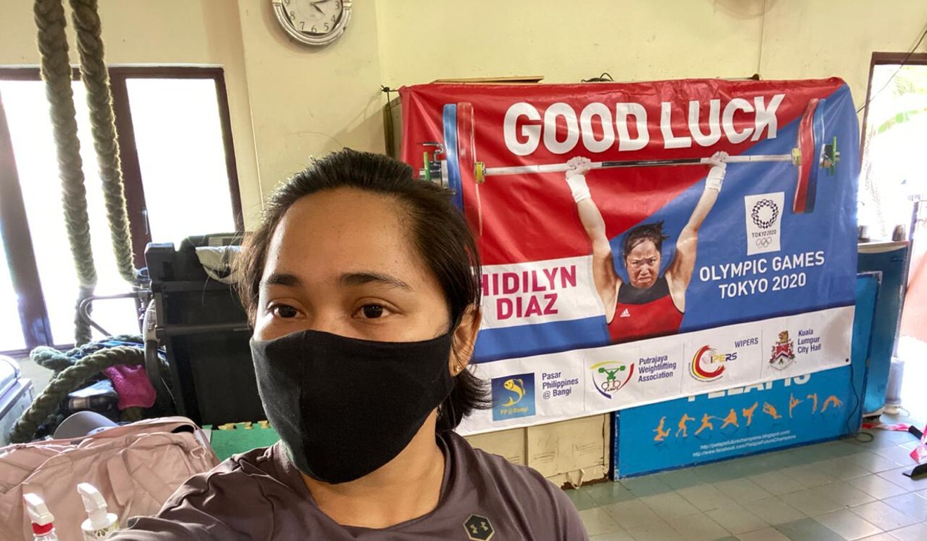 Hidilyn Diaz takes a selfie in front of a poster wishing her good luck for the Olympics in Jasin, Melaka, Malaysia. Photo: Handout