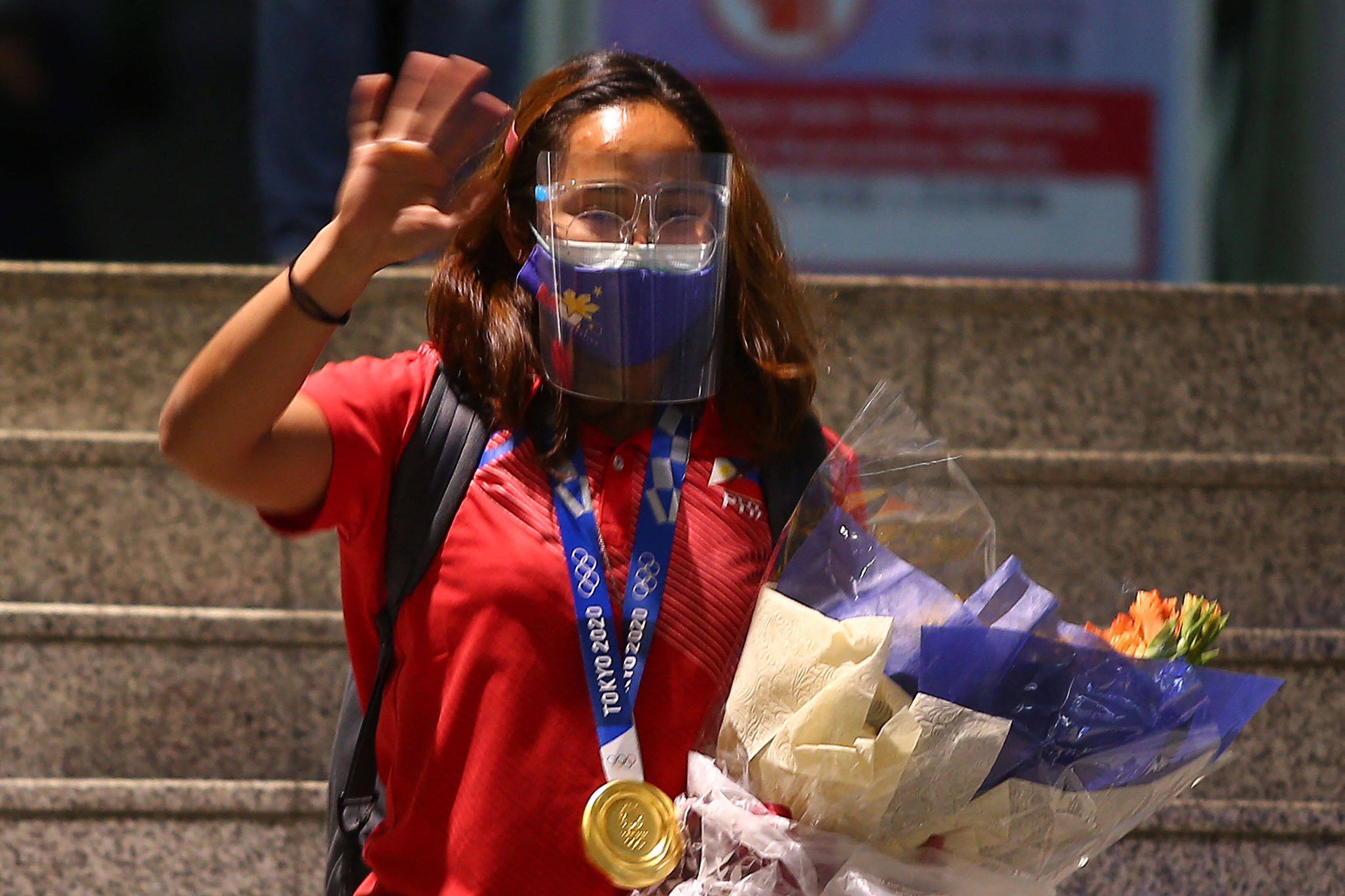 Philippine Olympic gold medallist Hidilyn Diaz waves to photographers as she arrives home in Manila on Wednesday. Photo: AFP