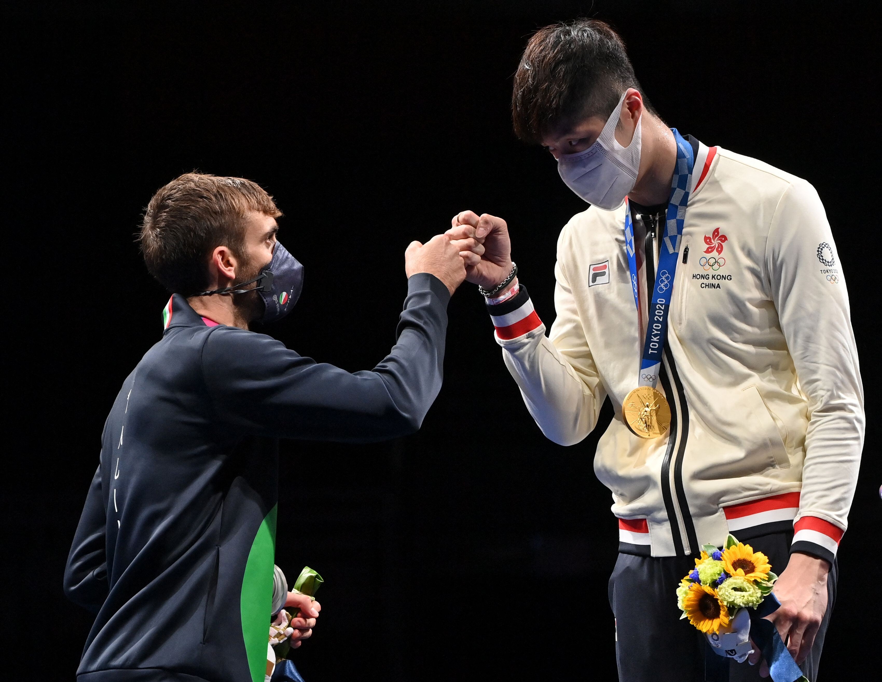 Hong Kong gold medallist Cheung Ka-long (right) fist bumps with Italy’s silver winner Daniele Garozzo at the medal ceremony in Tokyo. Photo: AFP