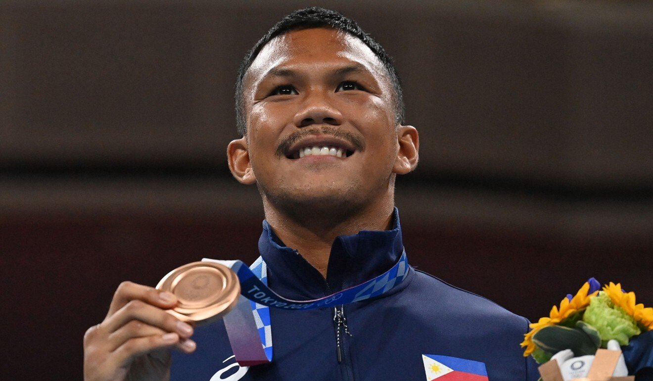 Bronze medallist Eumir Marcial celebrates on the podium during the medal ceremony for the men's middle (69-75kg) boxing final bout. Photo: AFP