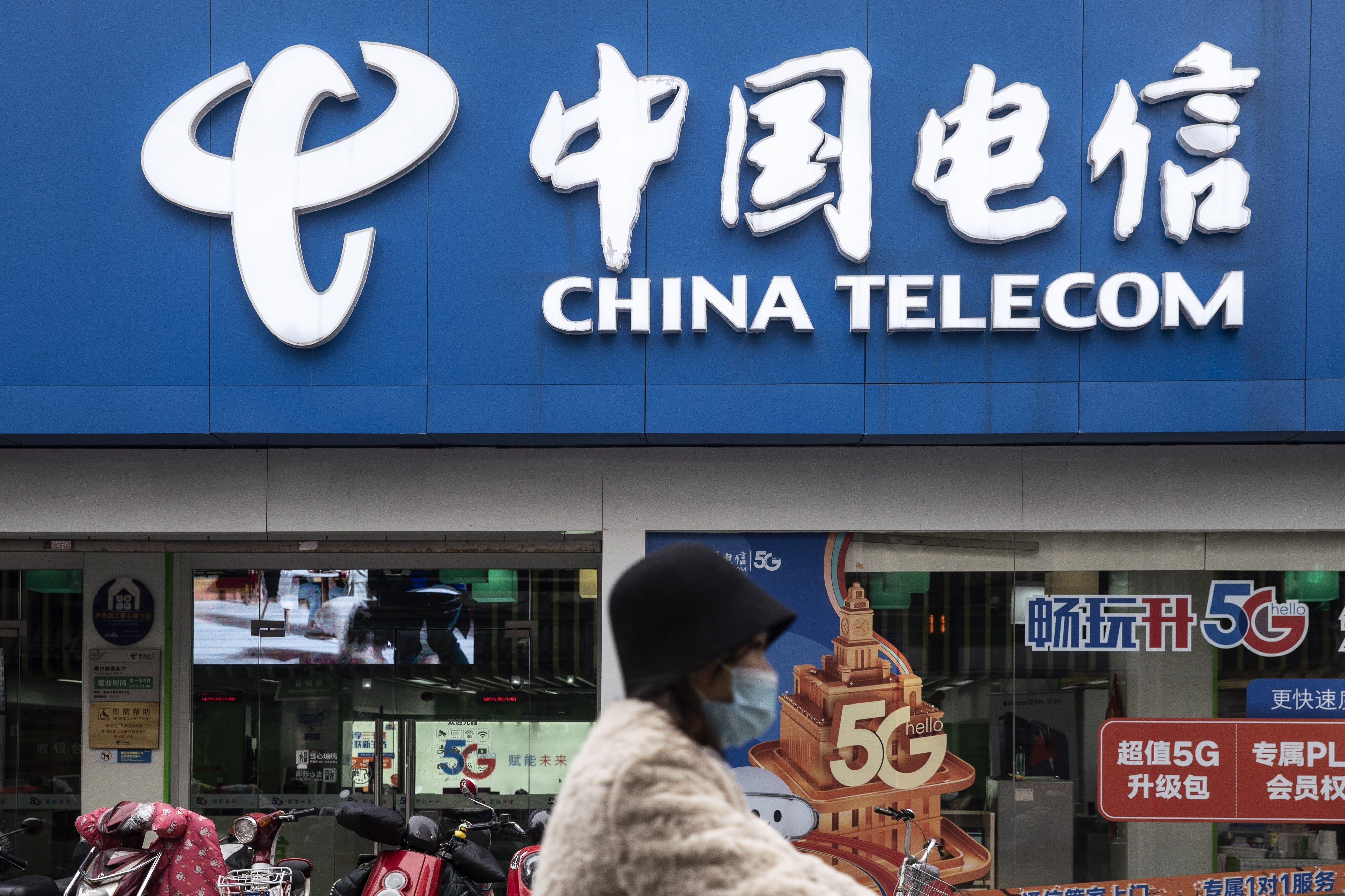 A motorist wearing a protective mask travels past a China Telecom Corp. store in Shanghai, China, on Wednesday, Jan. 6, 2021. Photo: Bloomberg