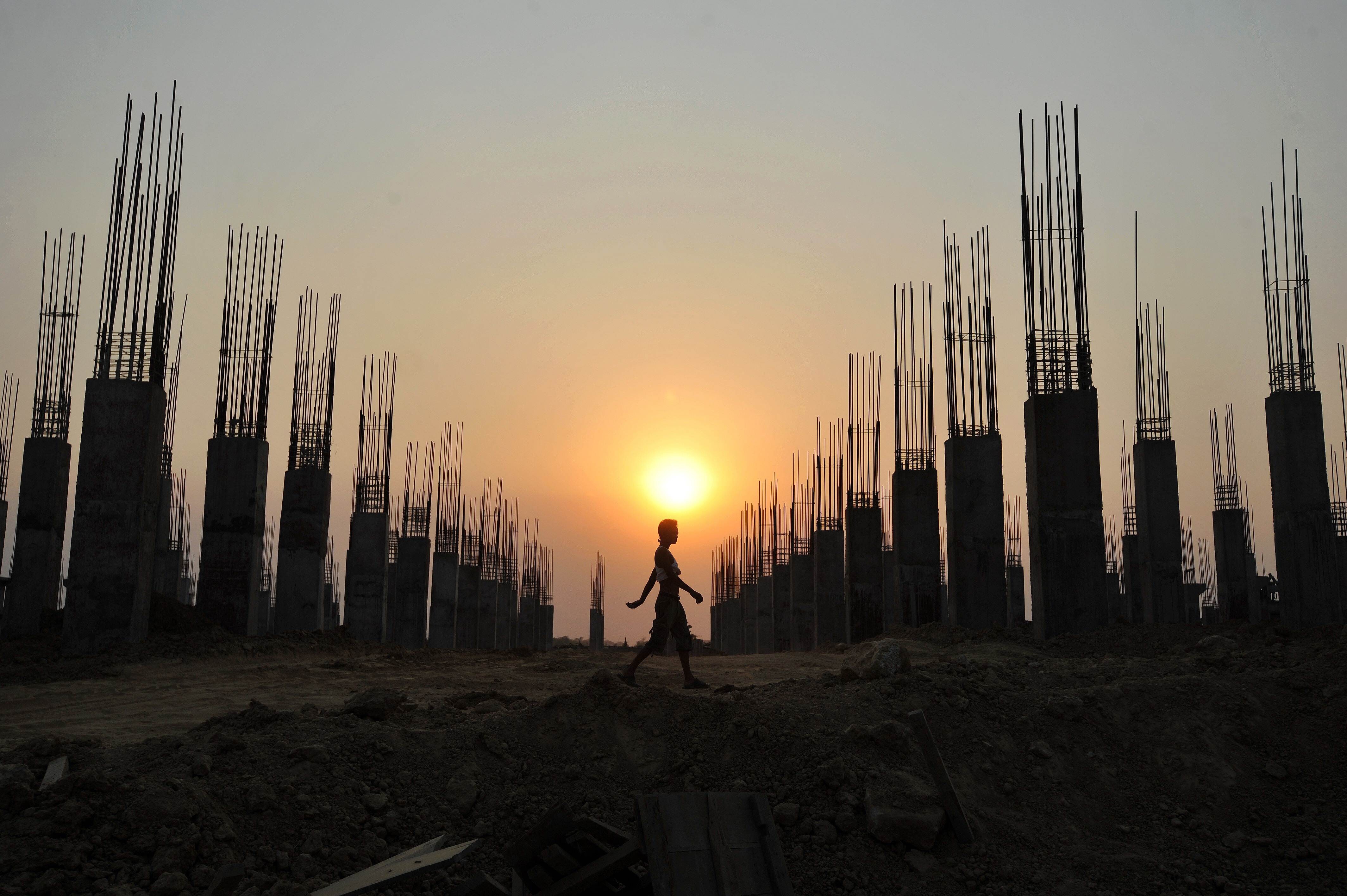 A construction worker walks past a construction site in Naypyidaw. Photo: AFP