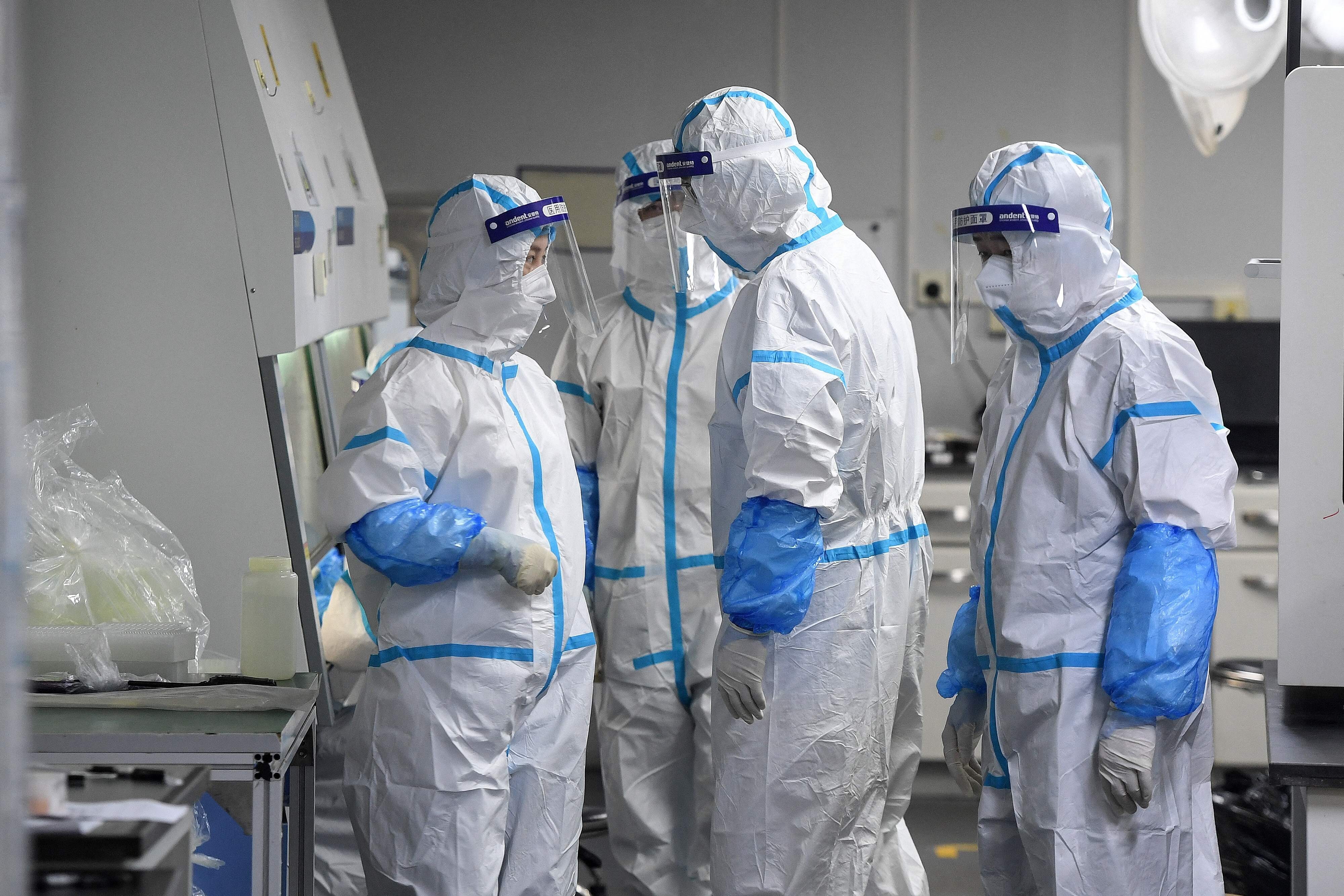 Laboratory technicians wearing personal protective equipment handle samples to be tested for Covid-19 in Wuhan, China, following an outbreak of the Delta variant in the city. Photo: AFP