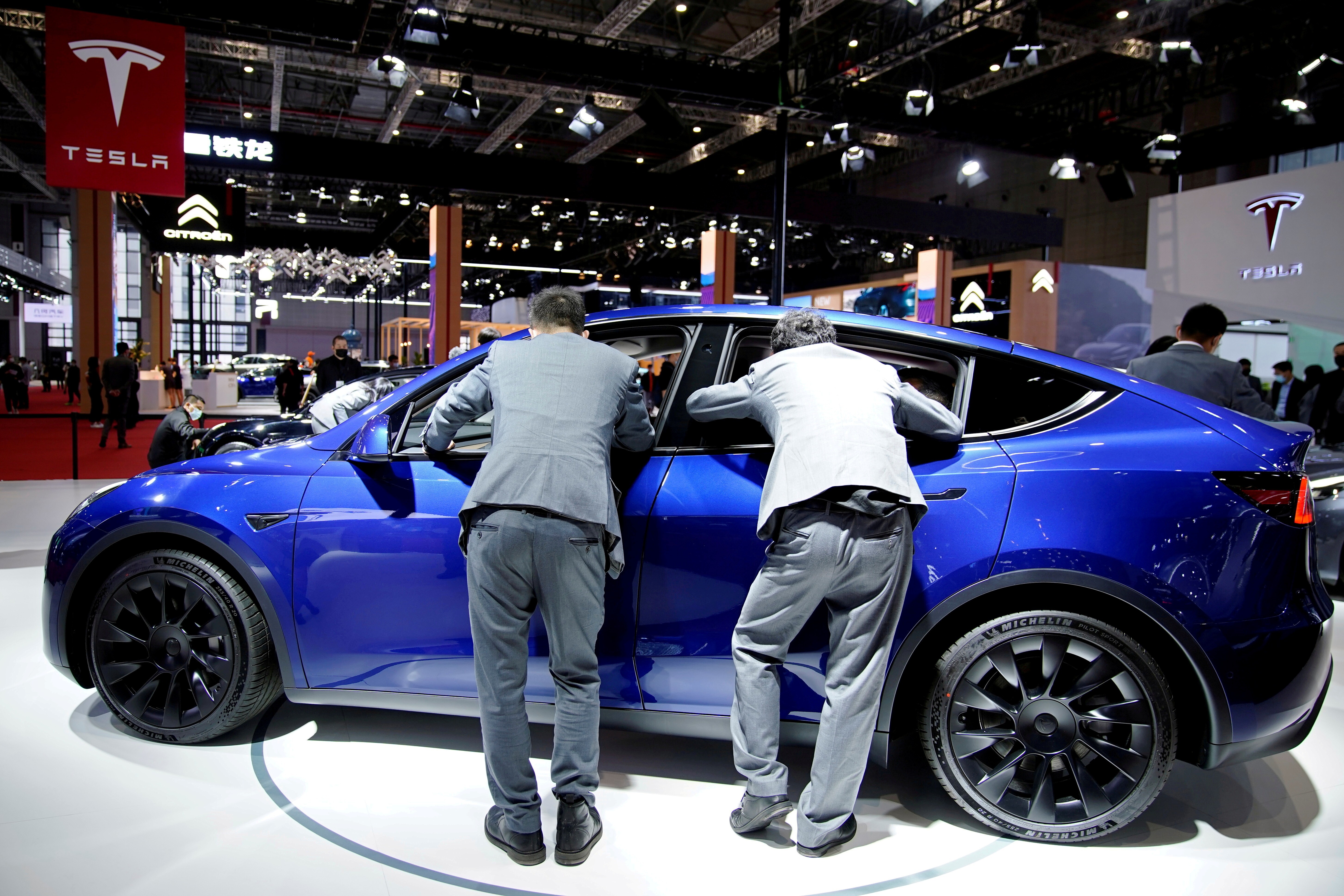 Visitors check an electric vehicle displayed at the Tesla booth during media day at the Auto Shanghai trade show on April 20, 2021. Photo: Reuters