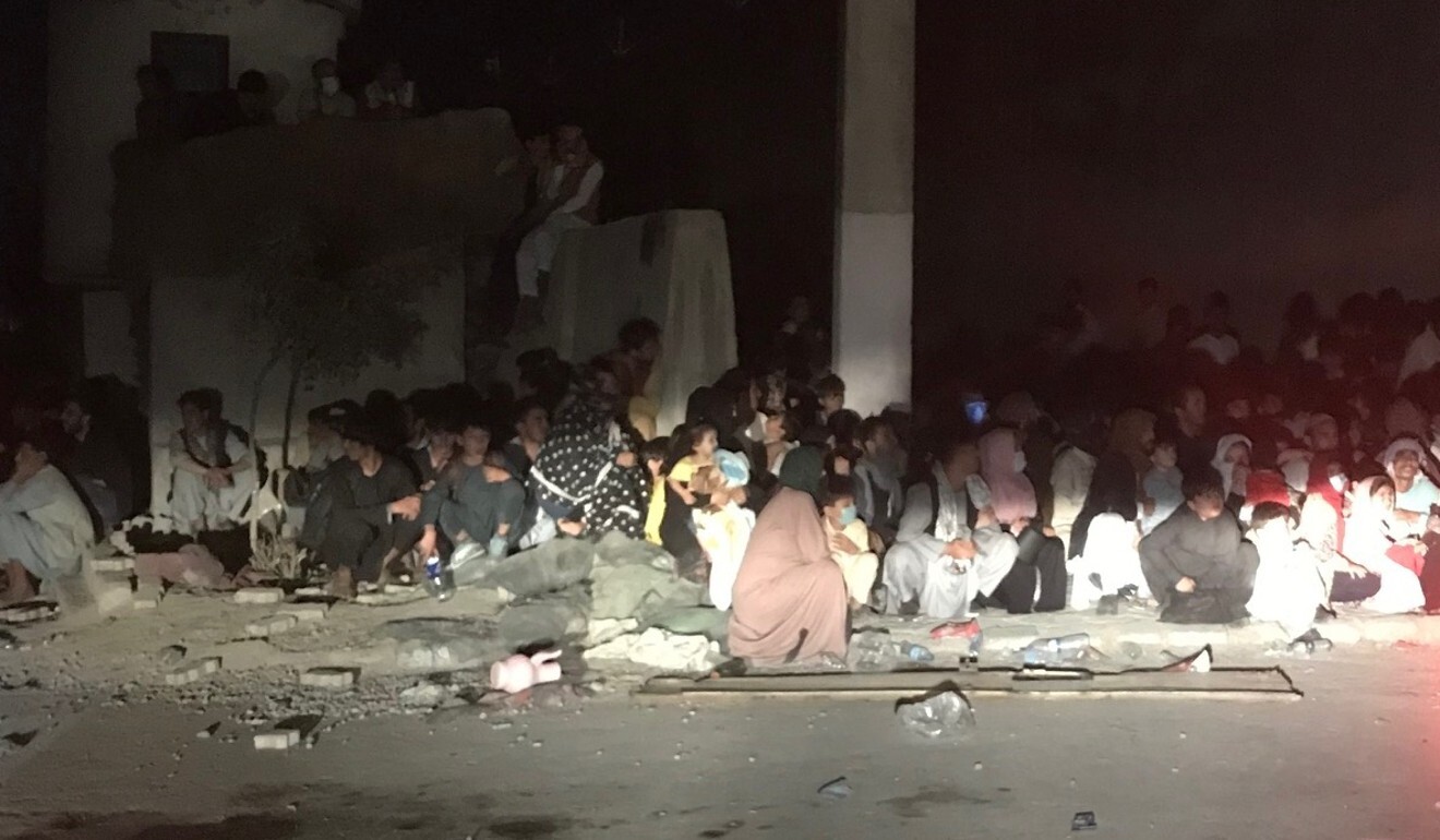 Afghan men and women sit on the road at the entrance to the airport in Kabul, desperate to leave the country. Photo: Sonia Sarkar