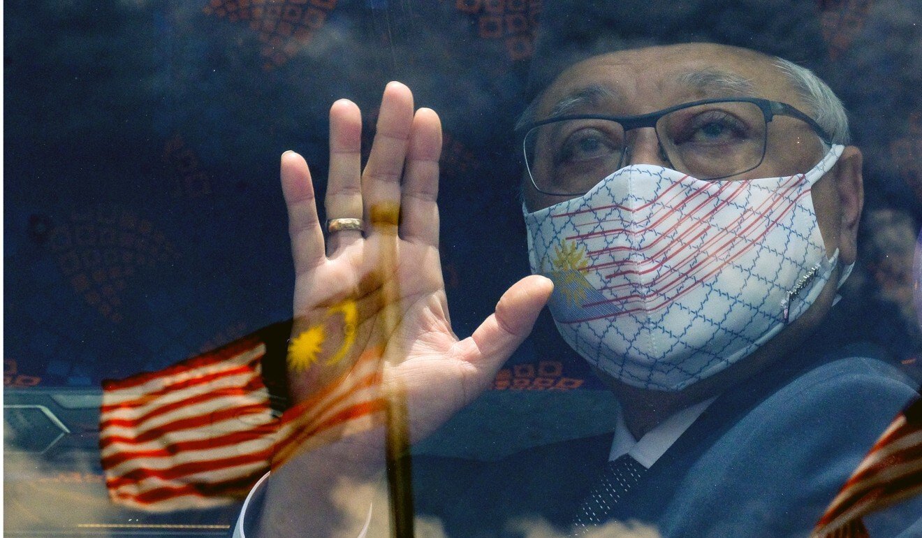 Ismail Sabri Yaakob waves from a bus with the Malaysian flag reflected in the window. Photo: Bloomberg