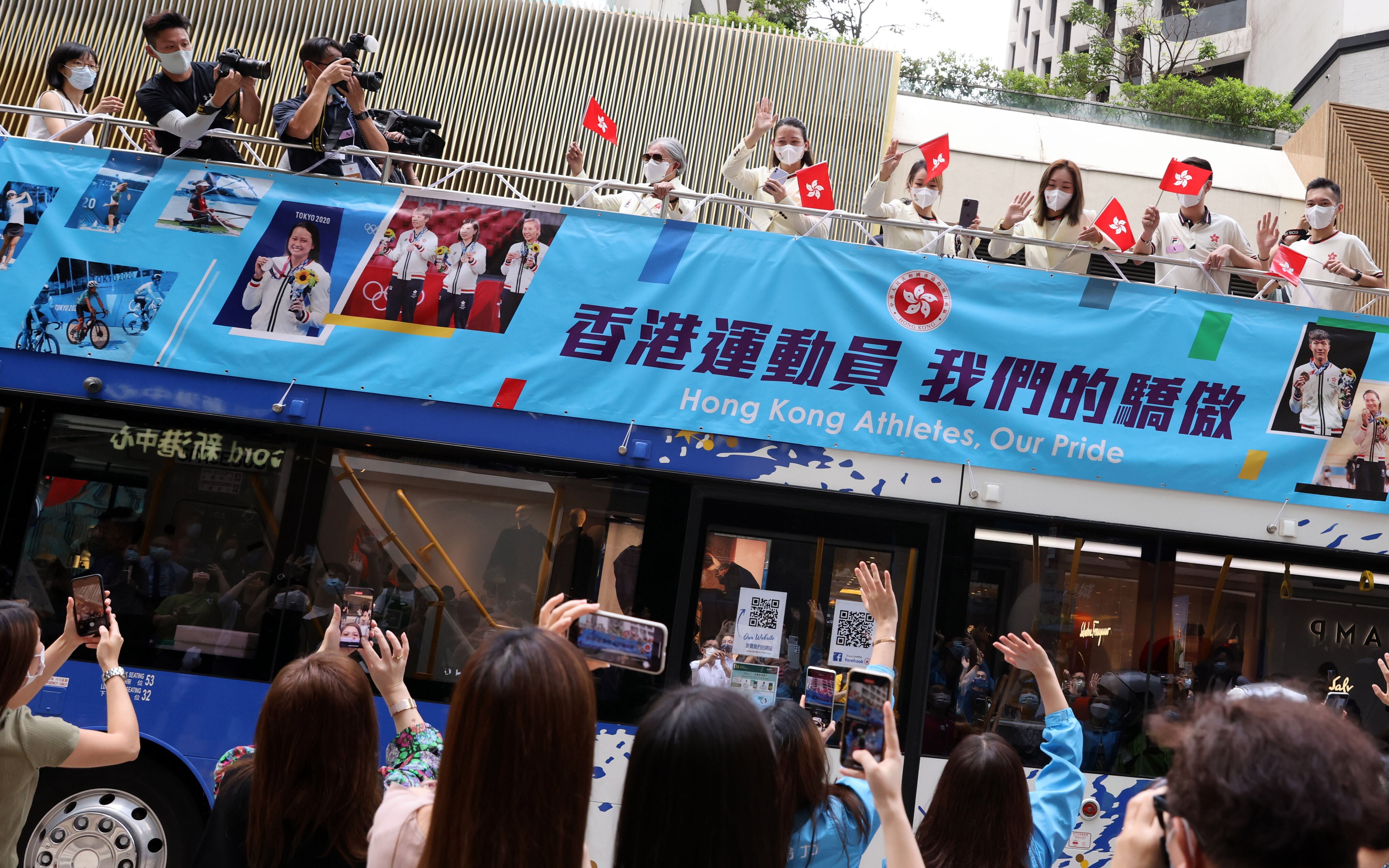 Hong Kong residents snap photos as the city’s Olympic team rolls along Thursday’s parade route. Photo: Nora Tam