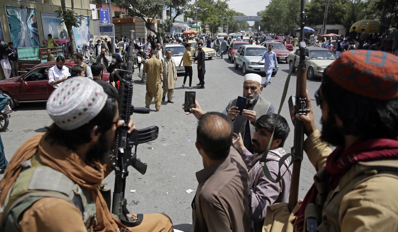 Afghans take selfie with Taliban fighters in Kabul. Photo: AP