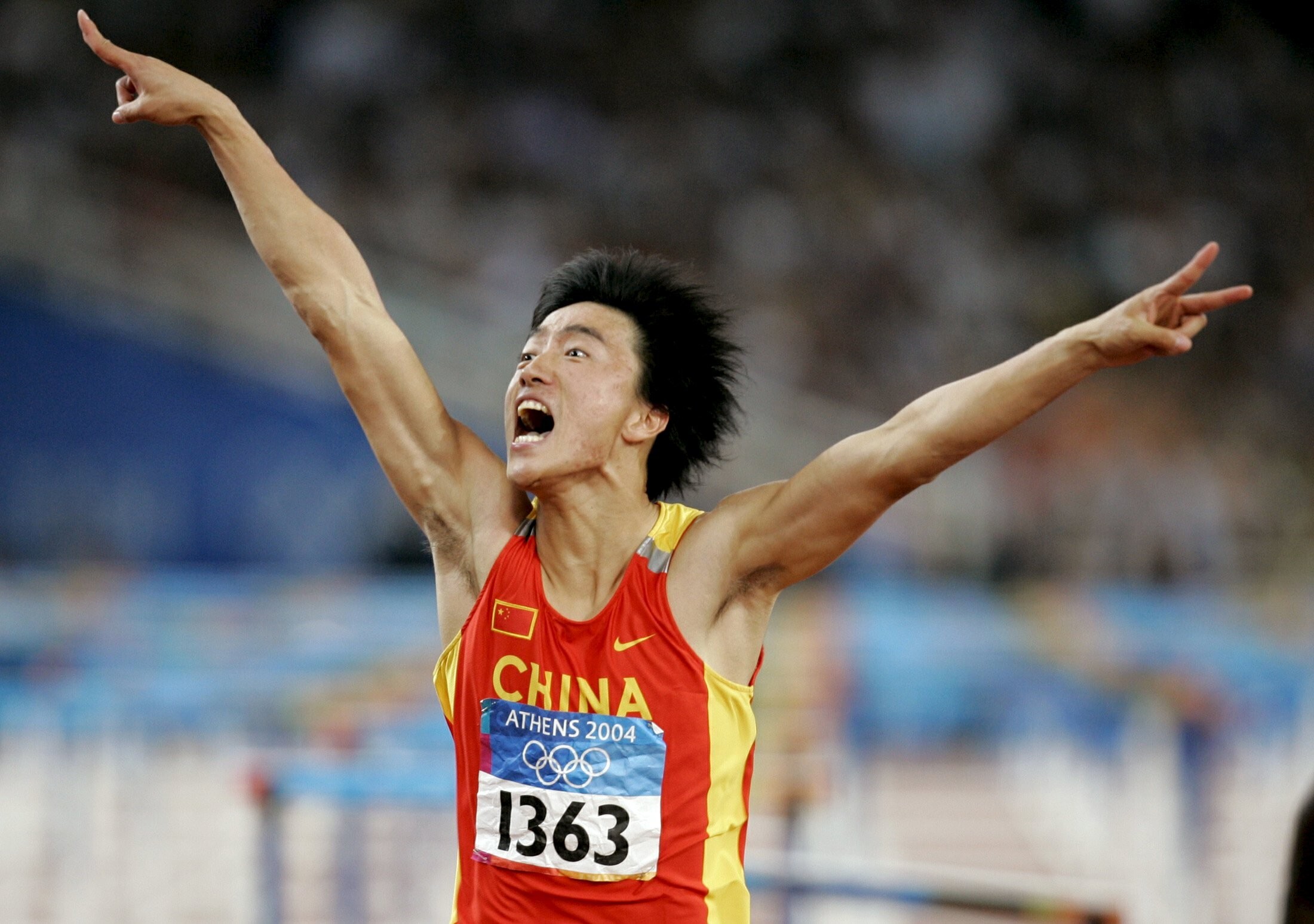 China's Liu Xiang celebrates as he crosses the finish line to win the men's 110 metres hurdle final at the Athens 2004 Olympic Games. Photo: Reuters