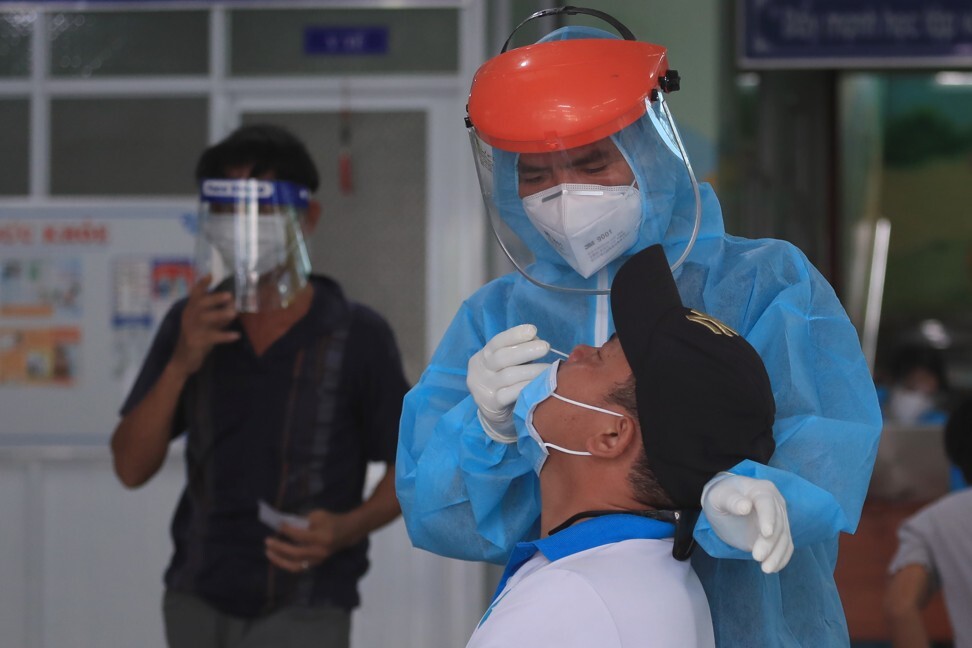 A Vietnamese medical worker takes a swab sample. Photo: AP