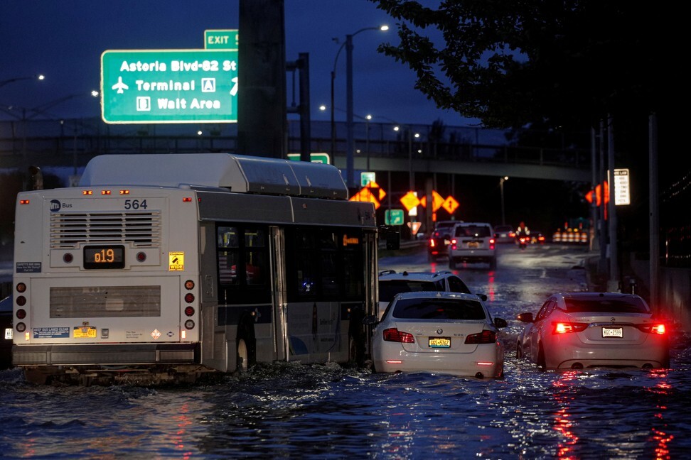 A bus navigates past abandoned cars on a flooded motorway in the Queens borough of New York City on Thursday. Photo: Reuters