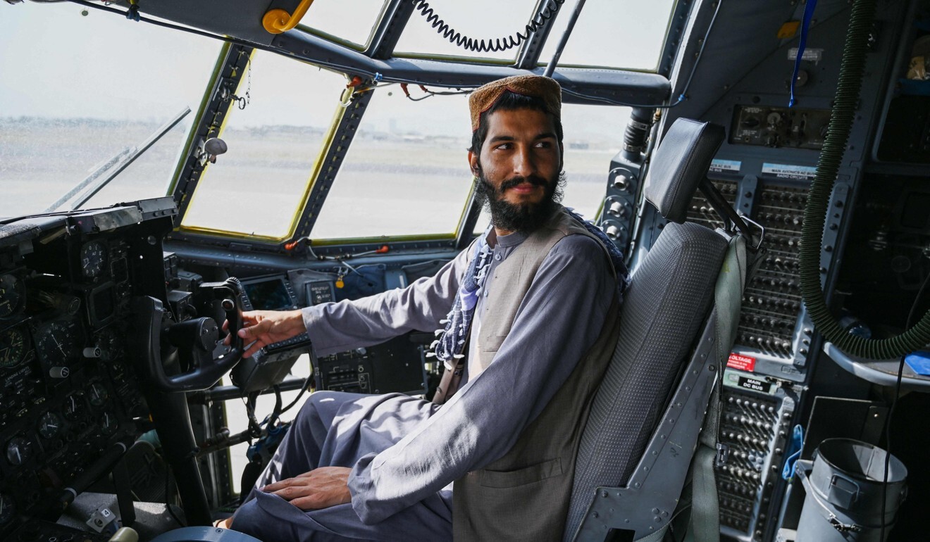 A Taliban fighter sits in the cockpit of an Afghan Air Force aircraft at the airport in Kabul. Photo: AFP