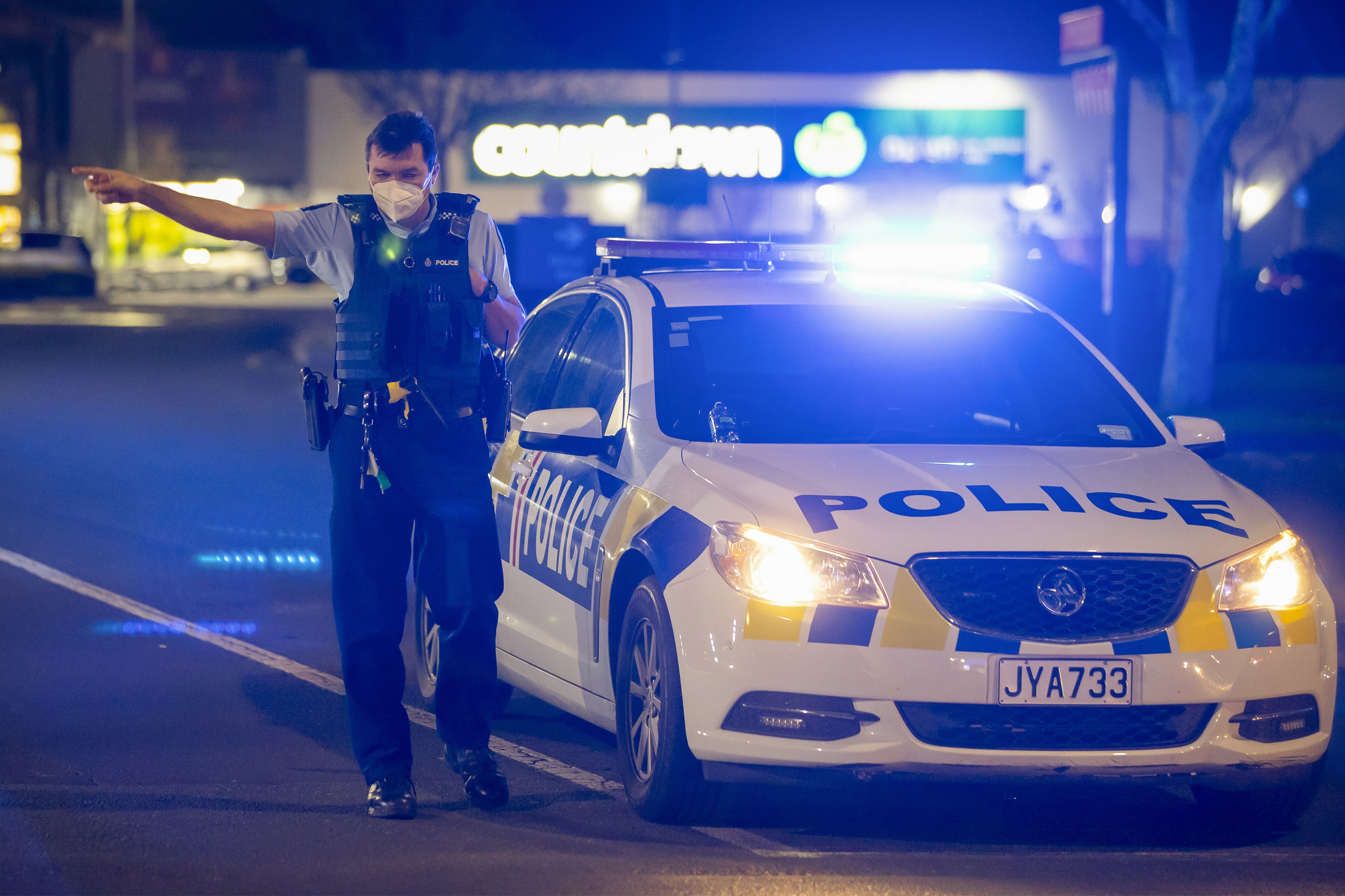 A police officer stands guard outside the New Lynn supermarket in Auckland. Photo: AP