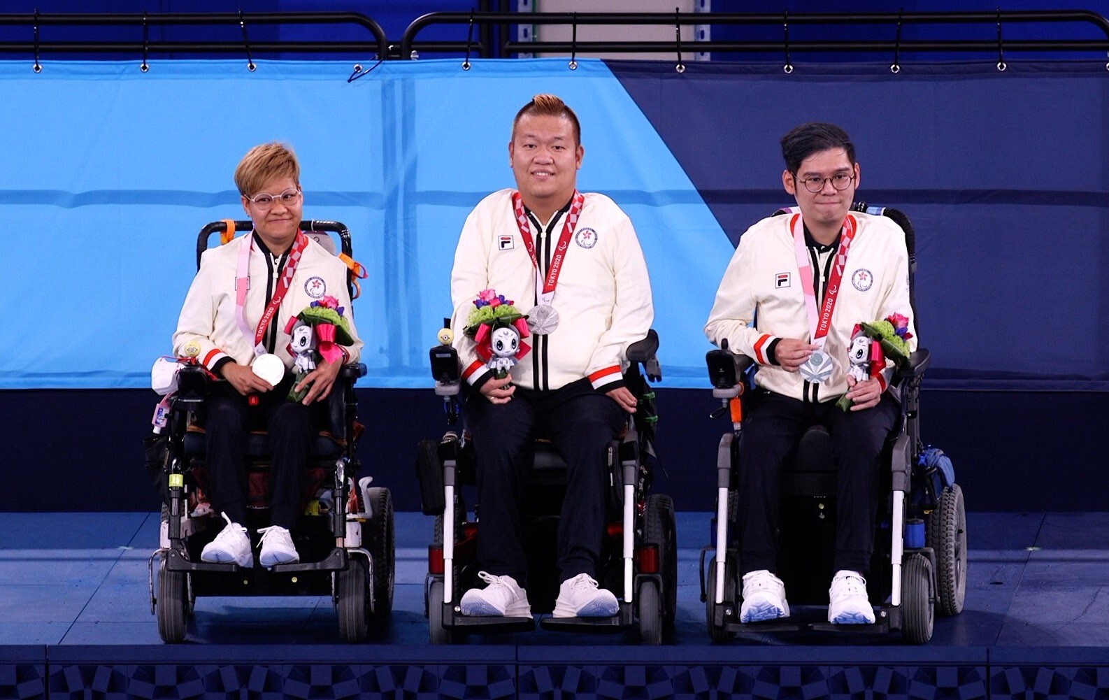 Hong Kong's Vivian Lau, Leung Yuk-wing and reserve player Raymond Wong celebrate on the podium after winning silver in the mixed pair BC4 event at the Tokyo Paralympics. Photo: Hong Kong Paralympic Association