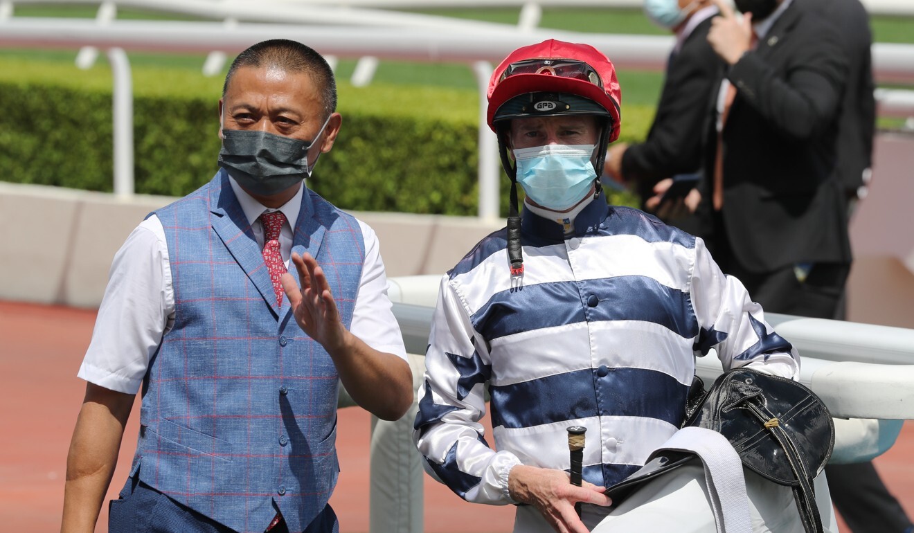 Trainer Danny Shum and jockey Zac Purton celebrate Packing Victory’s win.