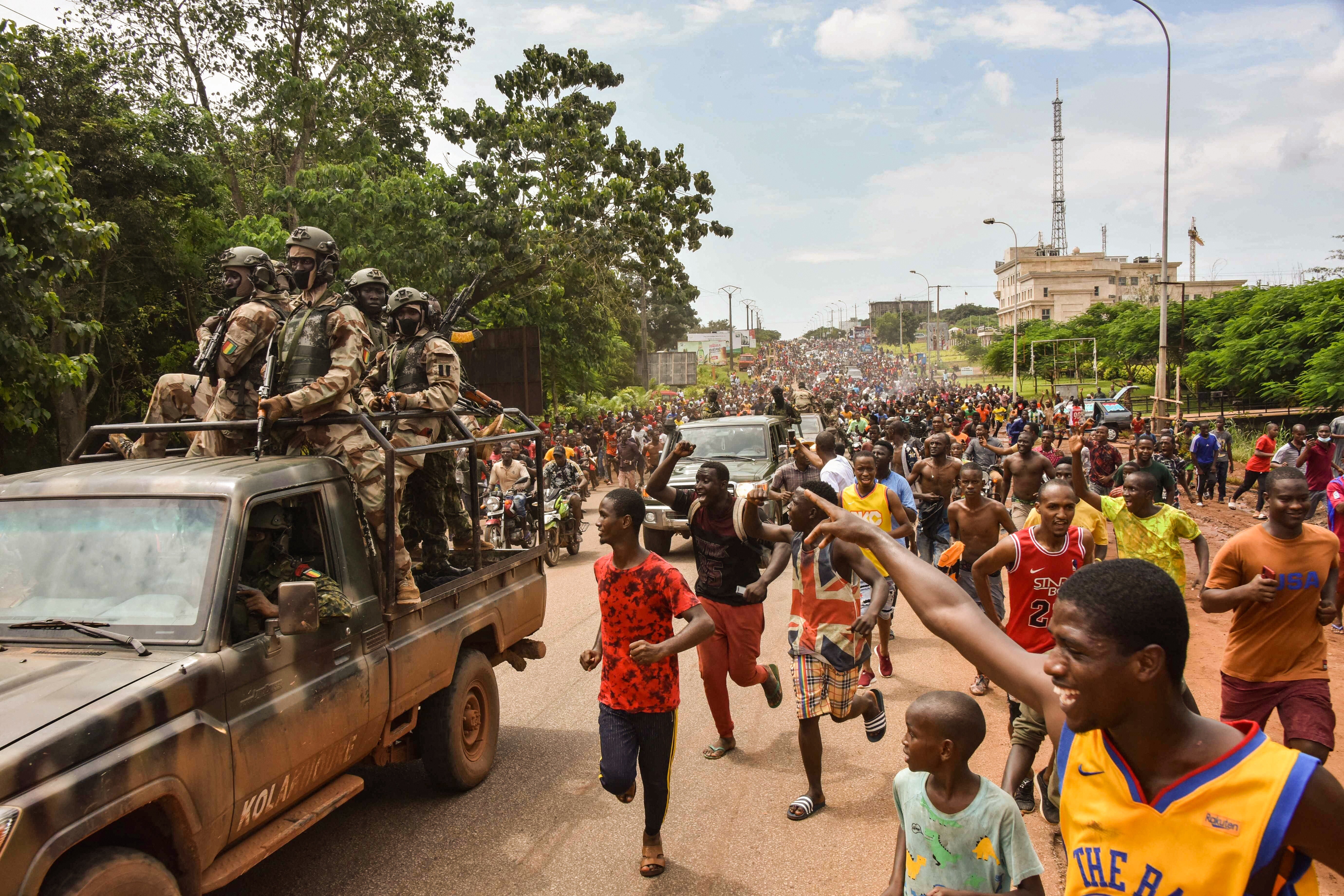 People celebrate in the streets with members of Guinea’s armed forces after the apparent arrest of president Alpha Condé in Conakry on Sunday. Photo: AFP