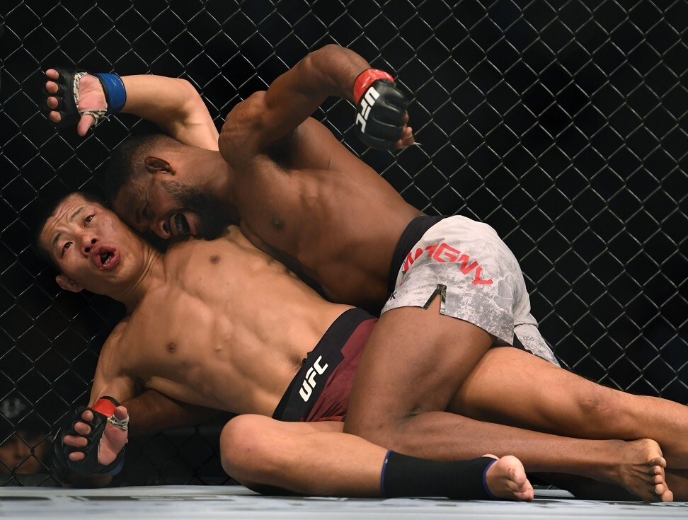 Neil Magny punches Li Jingliang en route to a unanimous win at UFC 248. Photo: AFP