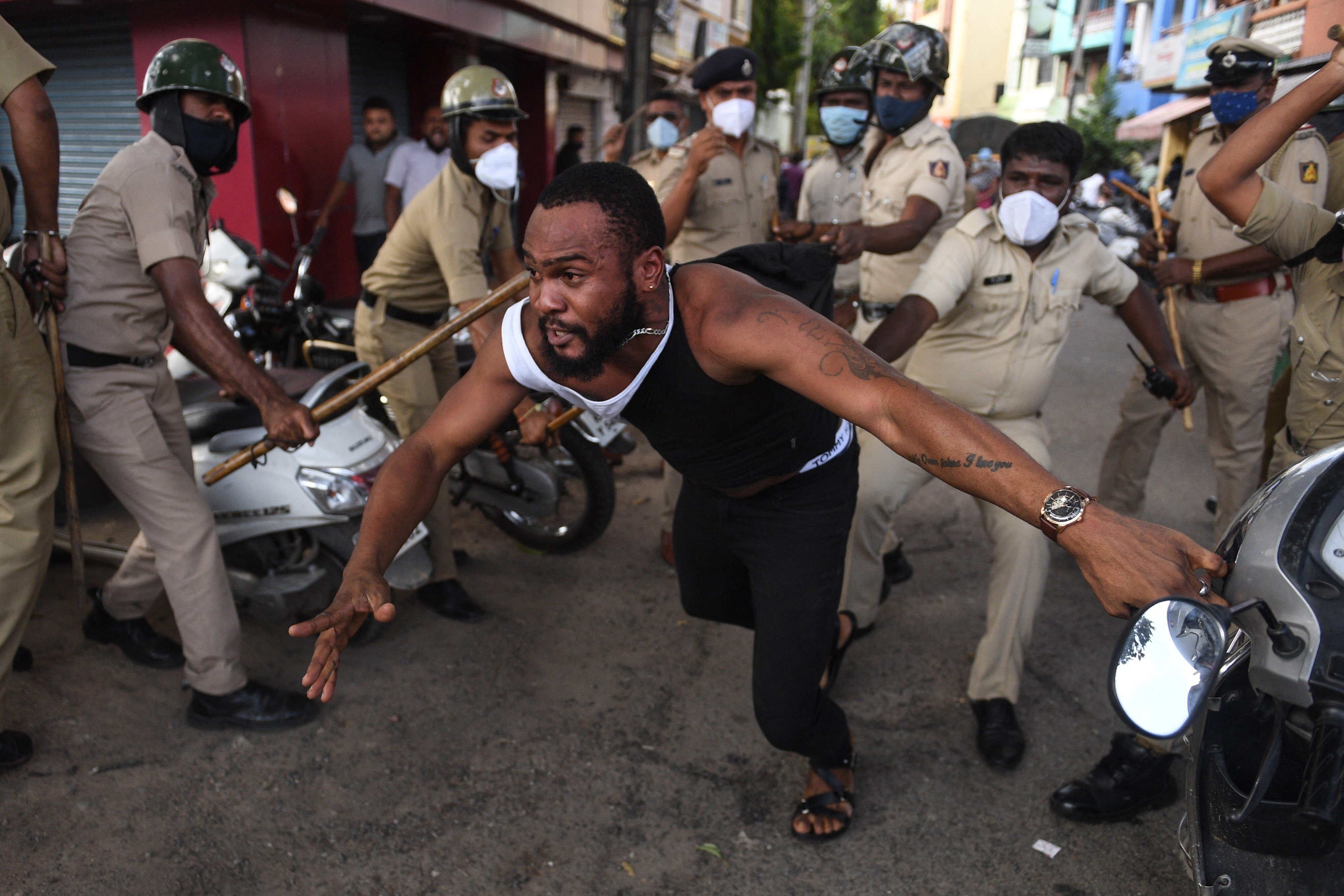 Police personnel in Bengaluru beat a man who was protesting the death of an African national in police custody. Photo: AFP