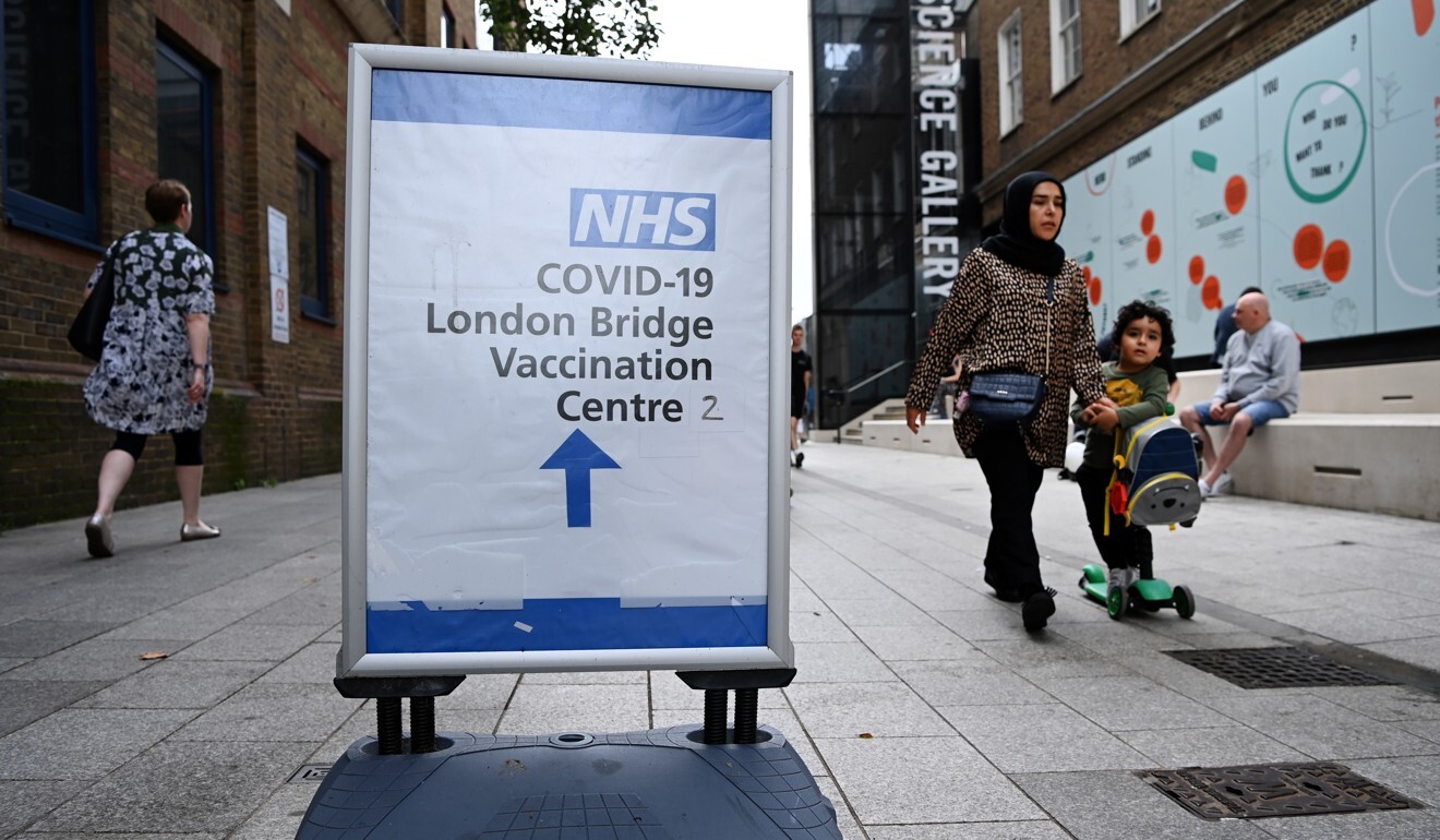 People walk past a Covid-19 vaccination sign outside a hospital in central London on Thursday. Photo: EPA