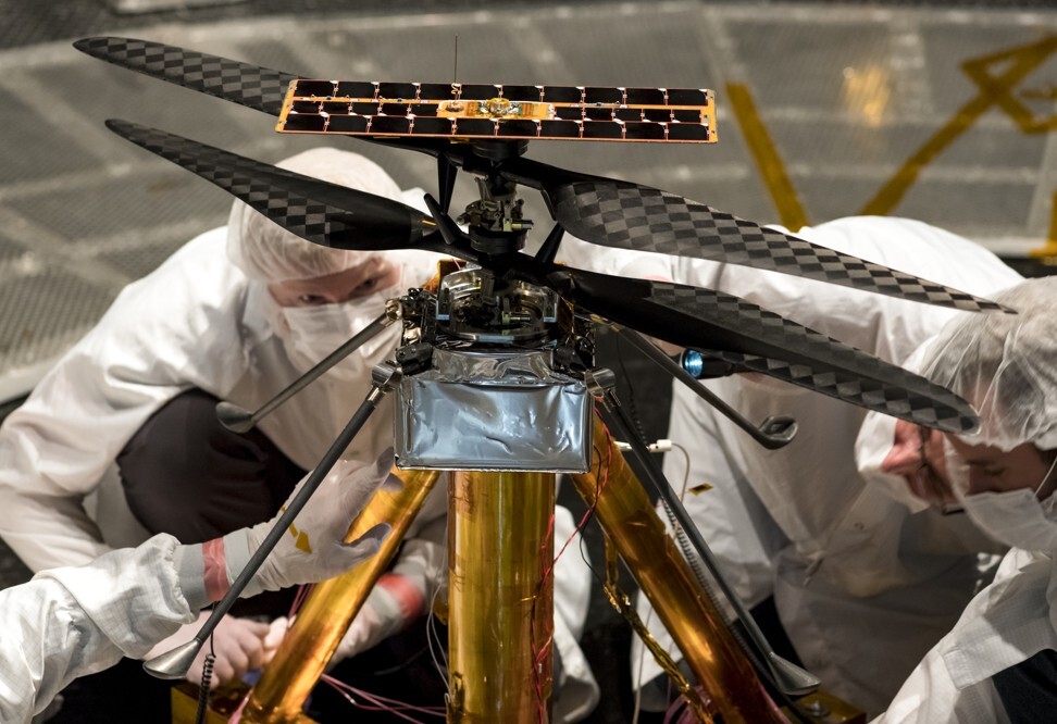 Members of the Nasa Mars Helicopter team inspect the flight model. Photo: Nasa