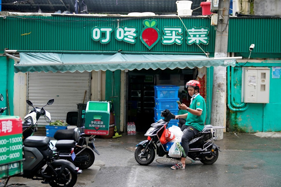 A delivery worker for Chinese online grocery Dingdong Maicai on a street in Shanghai on June 2021. Photo: Reuters.