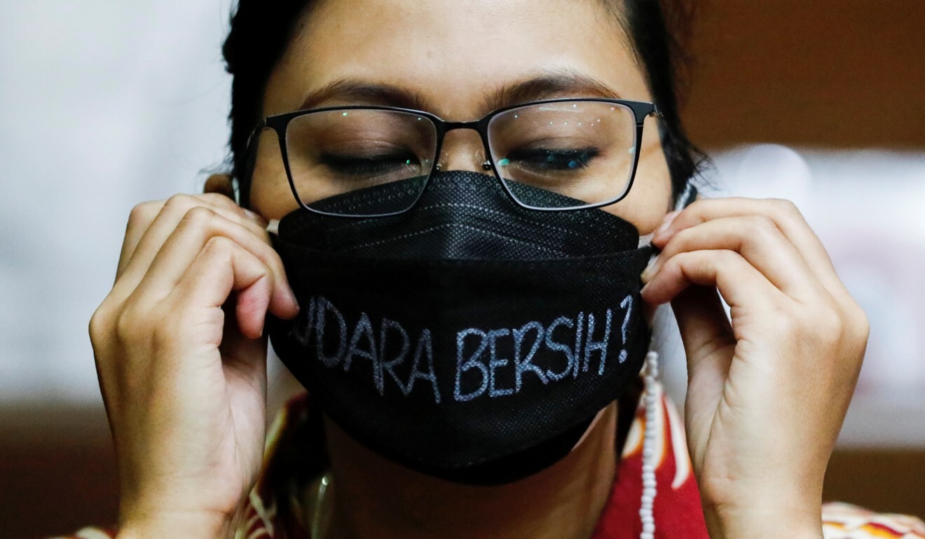 An environmental activist in the courtroom arranges her protective mask with the words “Clean Air?” on it in Indonesian Photo: Reuters