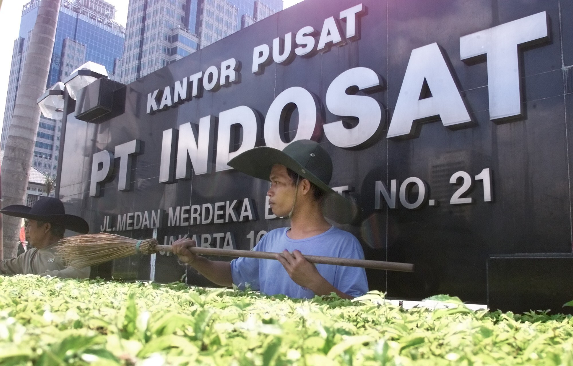 Gardeners working outside the head office of PT Indosat in Jakarta. Photo: AP