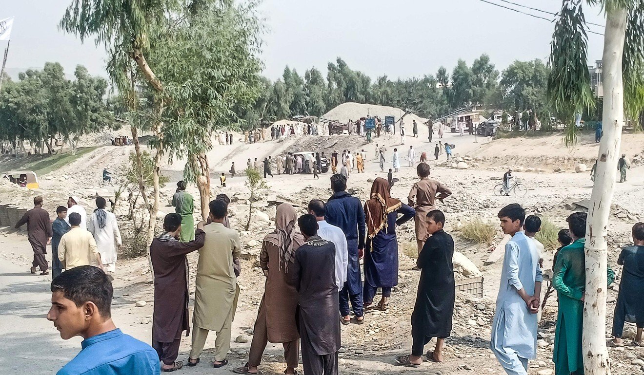 Taliban and Afghan civilians gather at the site of a bomb explosion in Jalalabad on Sunday. Photo: AFP