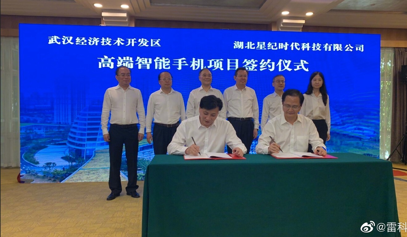 Officials from Hubei Xingji Shidai Technology and Wuhan Economic and Technology Development Zone sign an agreement for a smartphone venture in Wuhan on Tuesday. Photo: Weibo