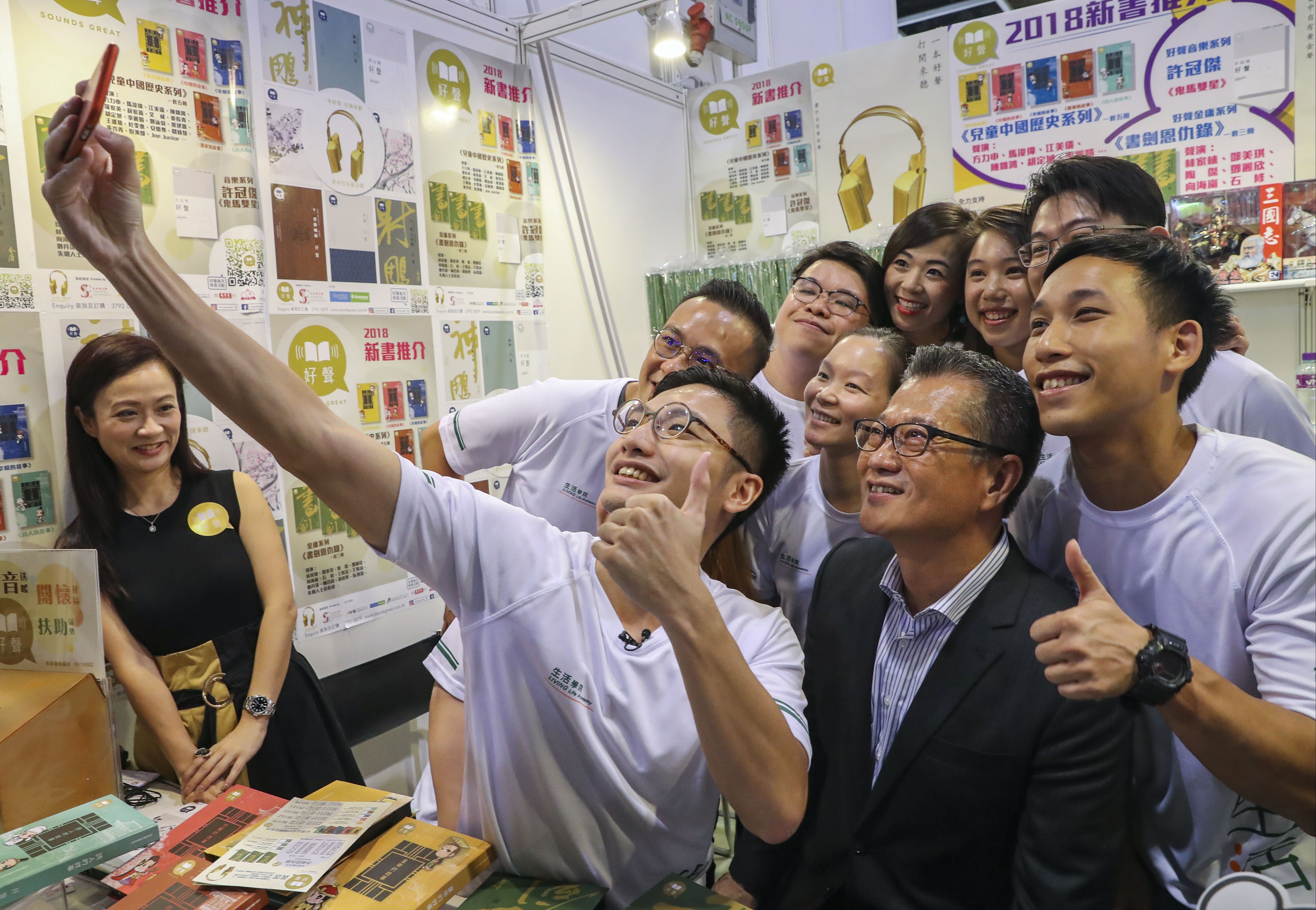 Financial Secretary Paul Chan (in black jacket) poses for a selfie with a group of admirers at the Hong Kong Book Fair. Photo: K. Y. Cheng