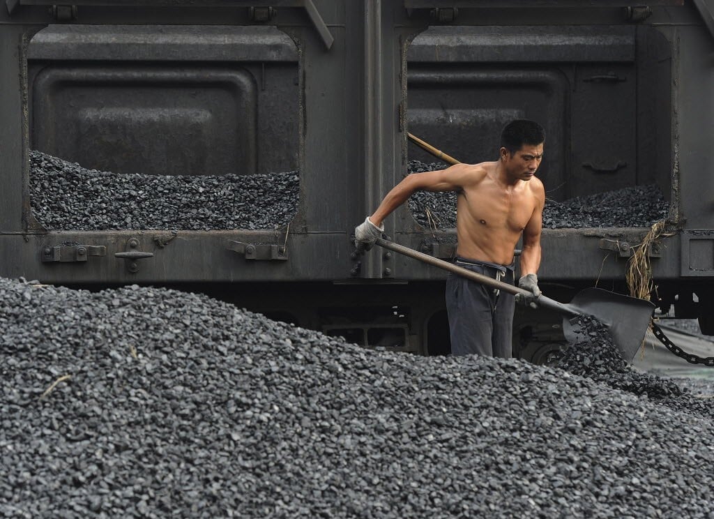 A man shovels coal at a storage site in Anhui province. China is looking at ways to address a critical coal shortage that has led to widespread power outages. Photo: Reuters