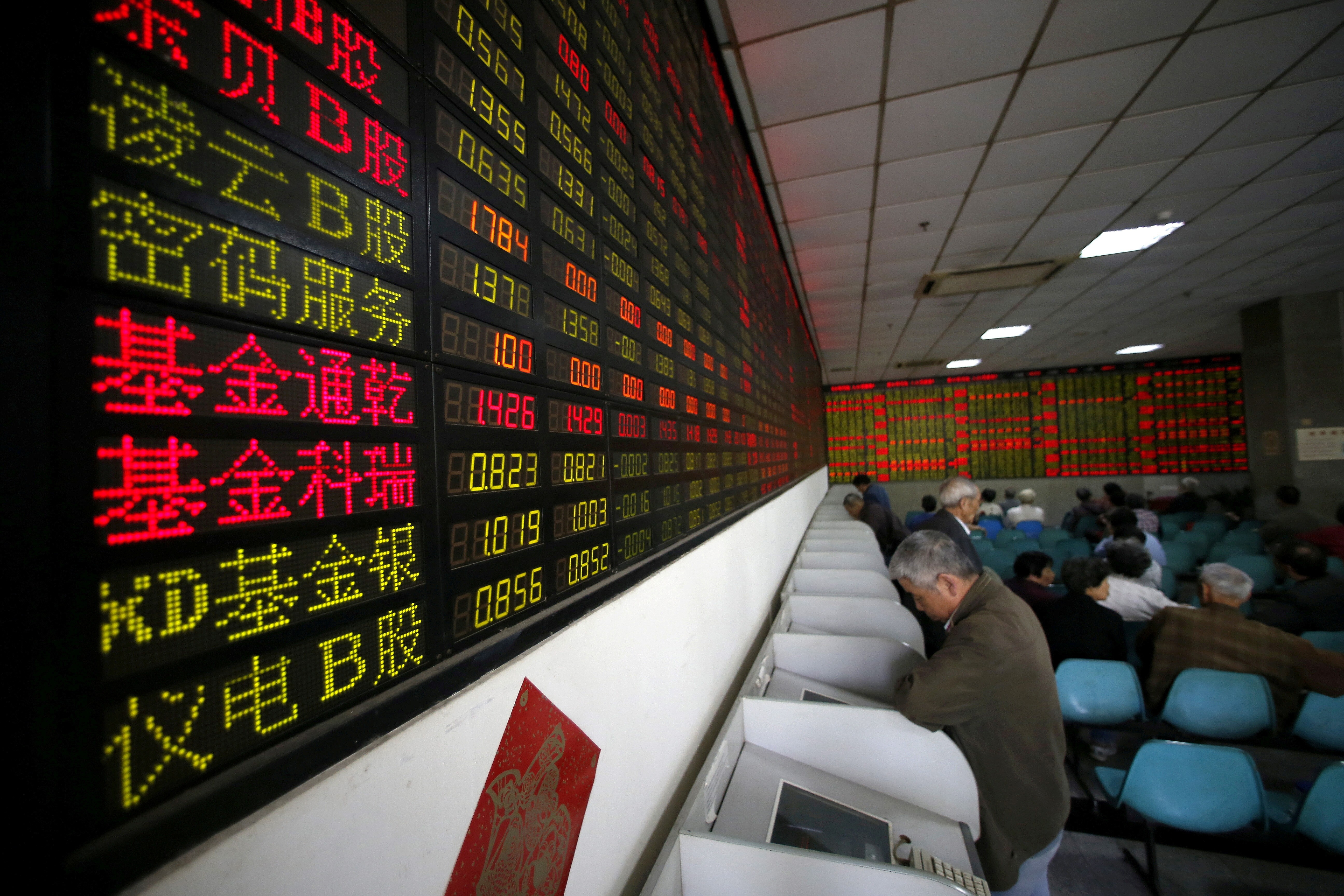 Investors look at computer screens showing stock prices at a brokerage house in Shanghai. Photo: Reuters