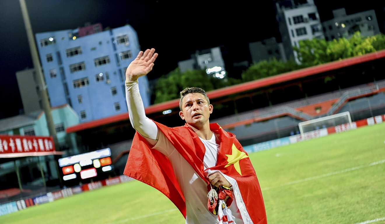 China’s Brazilian-born forward Elkeson, Chinese name Ai Kesen, celebrates with a Chinese flag at the end of the Qatar 2022 Fifa World Cup second round group A qualification win over Maldives. Photo: AFP