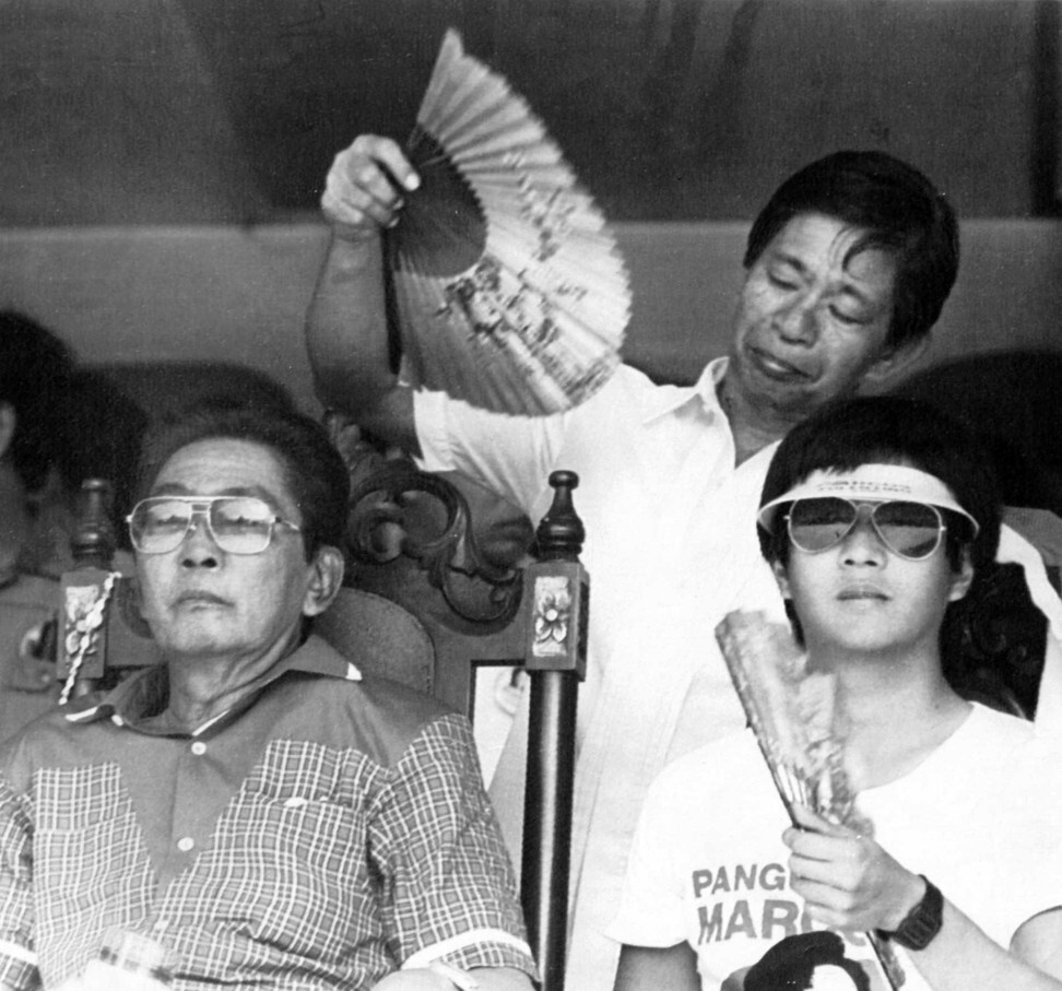 Ferdinand Marcos Snr and his son Ferdinand ‘Bongbong’ Jnr are fanned by a bodyguard in 1986. Photo: Reuters