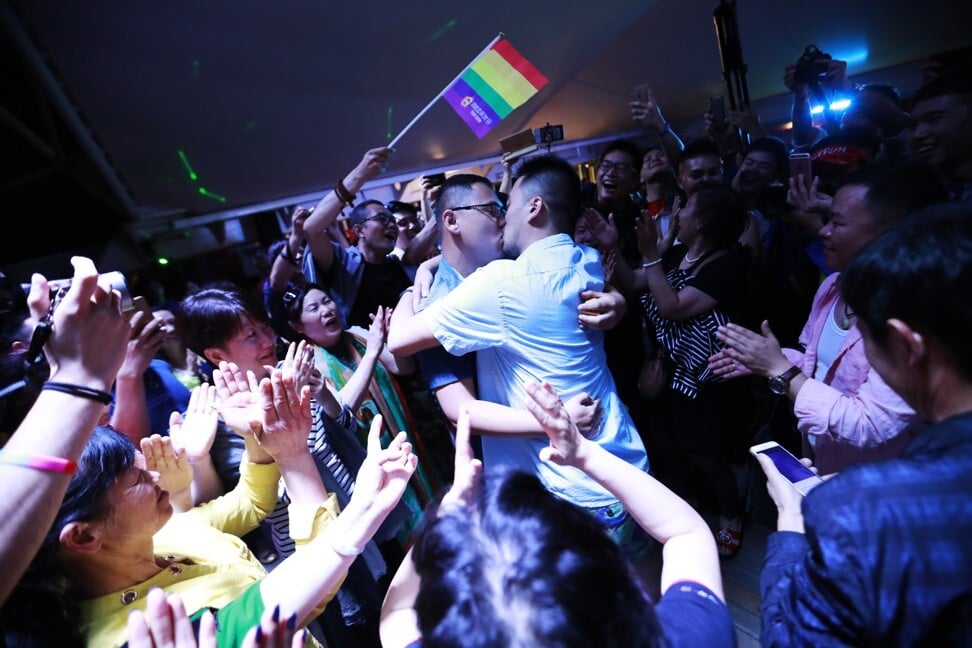 A gay couple kisses during a party after a LGBT mass wedding organised by the Parents and Friends of Lesbians and Gays (PFLAG) China organisation on a cruise in open seas on route to Sasebo, Japan, 15 June 2017. Photo: EPA