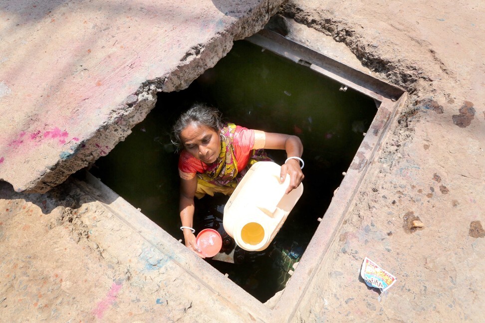 An Indian woman collects drinking water from a tap on the roadside. Photo: EPA