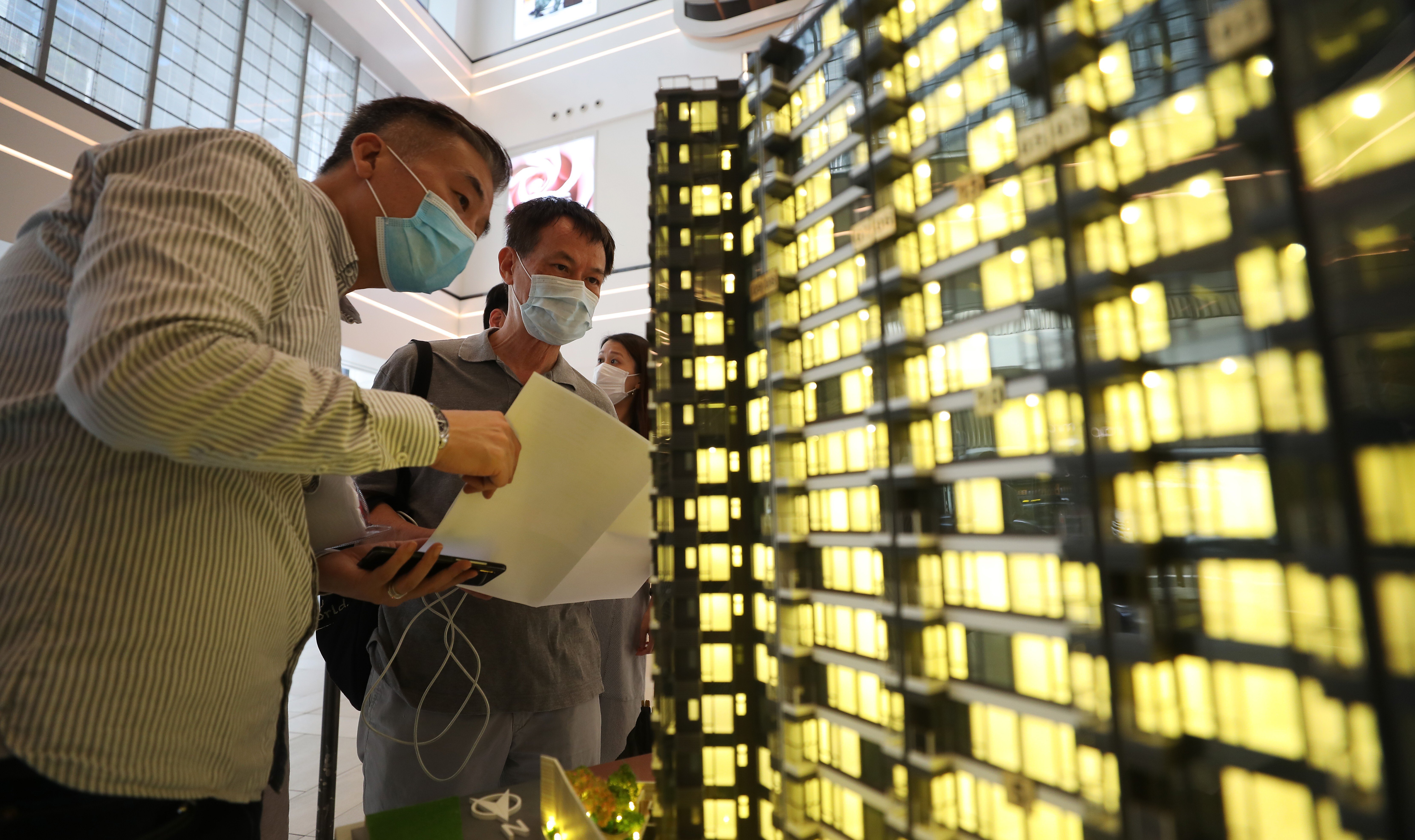 Potential homebuyers inspect a model of a new residential project. Photo: Xiaomei Chen
