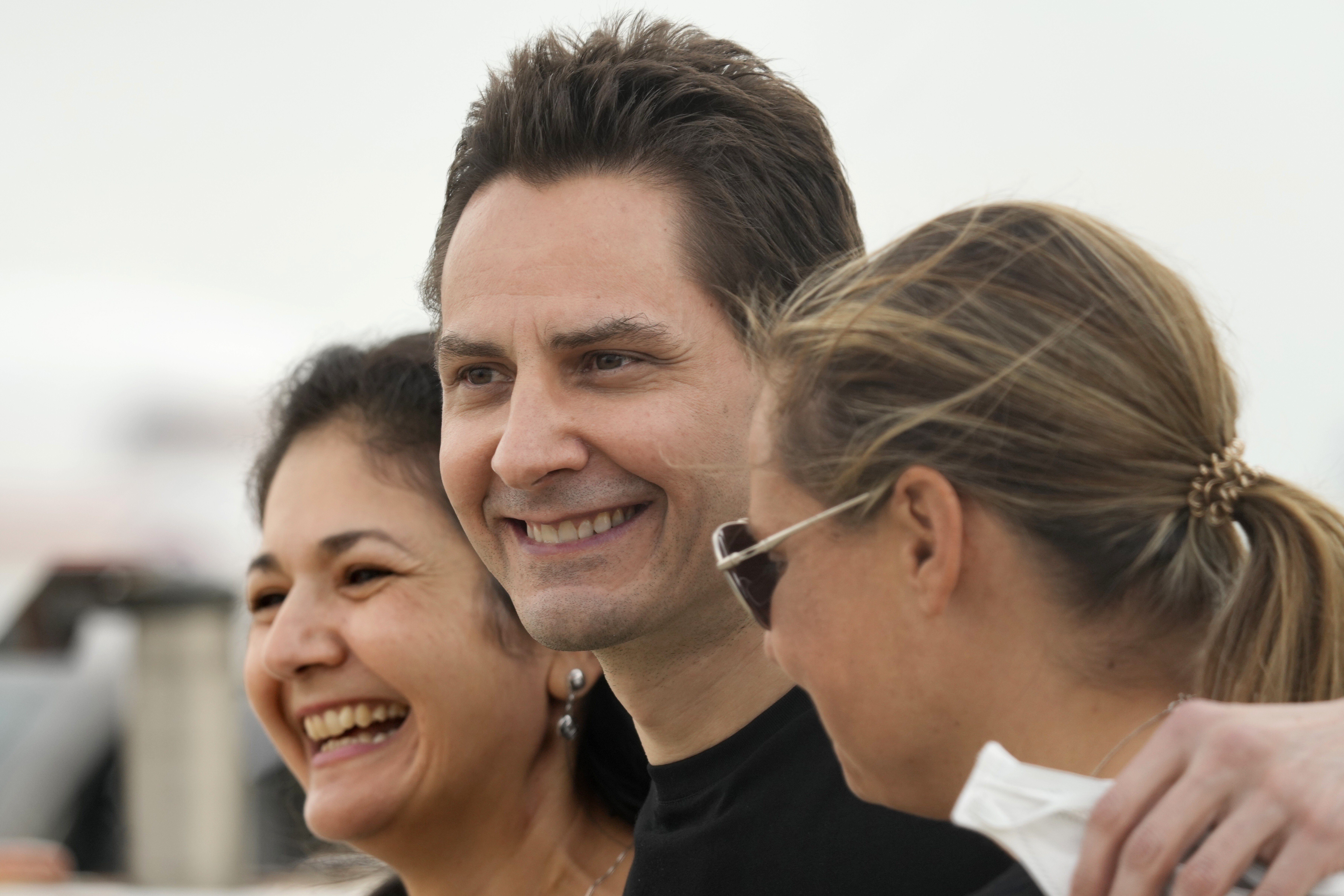 Michael Kovrig embraces his wife Vina Nadjibulla, left, and sister Ariana Botha after arriving at Pearson International Airport in Toronto on September 25. Photo: The Canadian Press via AP