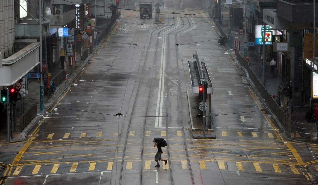 A man dashes across an empty street in Hong Kong’s normally busy Central district during Wednesday No 8 typhoon warning. Photo: Nora Tam