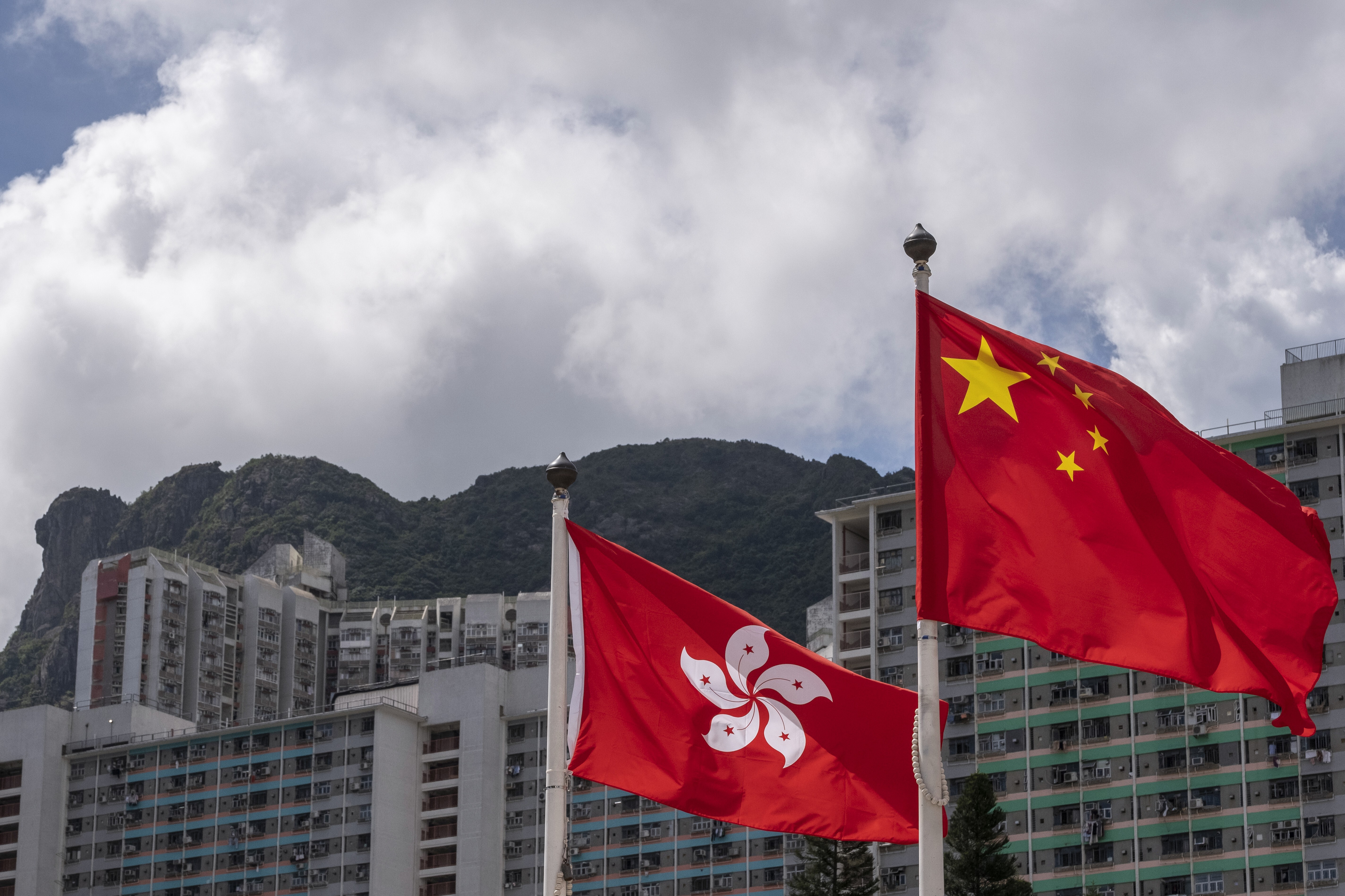 The Hong Kong and Chinese flags wave on masts in Wong Tai Sin, Hong Kong. Photo: Sun Yeung