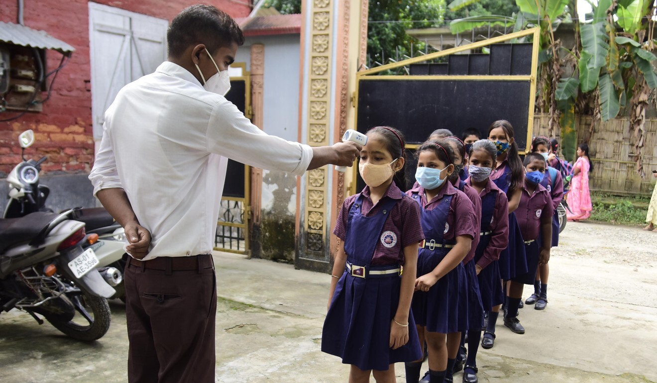 Pupils get their temperatures checked at a school in India’s northeastern state of Assam. Photo: Xinhua