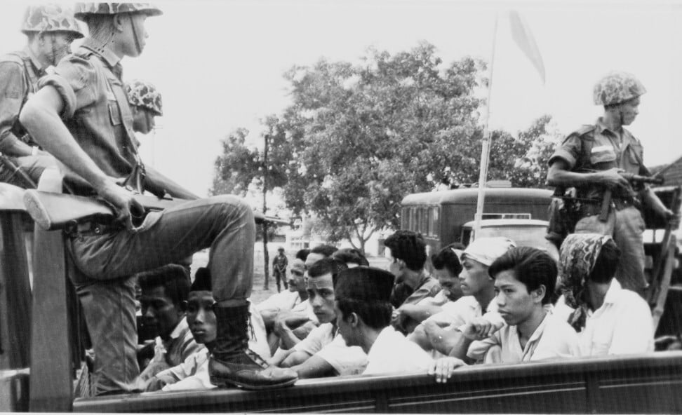 Members of the Youth Wing of the Indonesian Communist Party are guarded by soldiers as they are taken by open truck to prison in Jakarta in 1965. Photo: AP