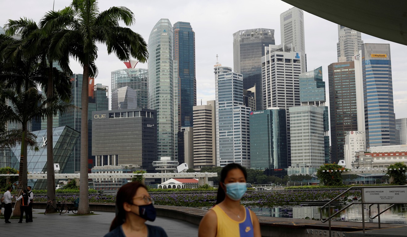 Pedestrians pass the Singapore skyline. Photo: Reuters